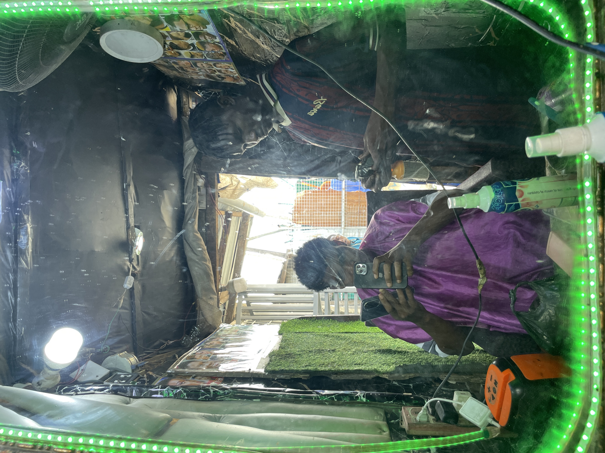Inside a Lagos barbershop, mirrors and street life