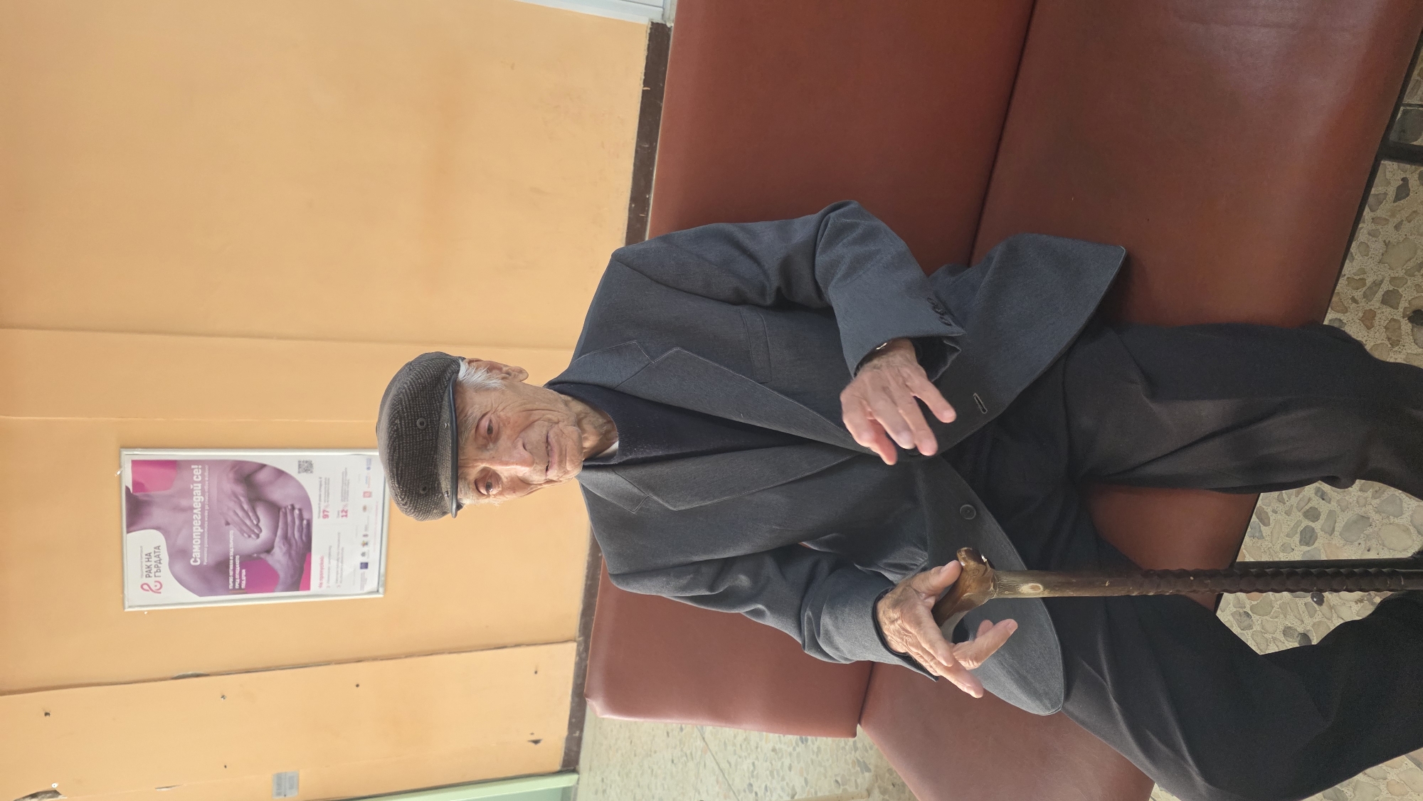 Elderly man waits in Blagoevgrad room with cane