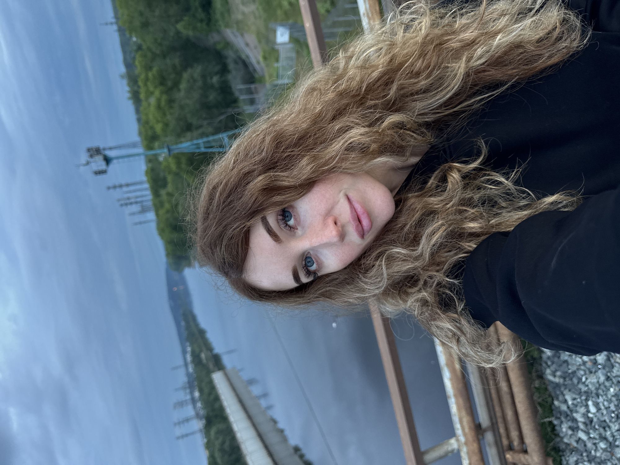 Exploring a fenced industrial riverfront in Chaikovsky with a Samoyed