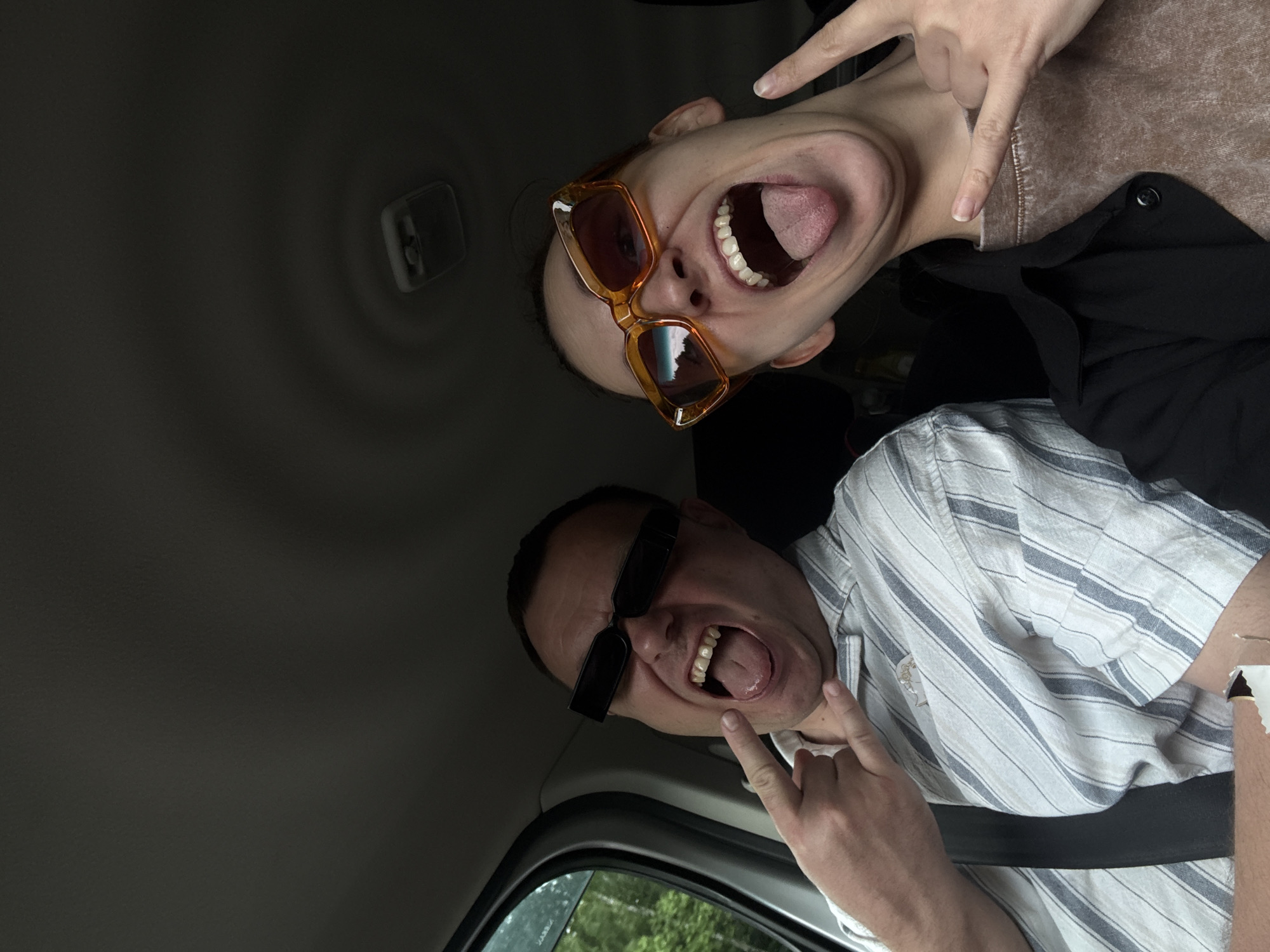 Two people make playful gestures inside vehicle in Shadki