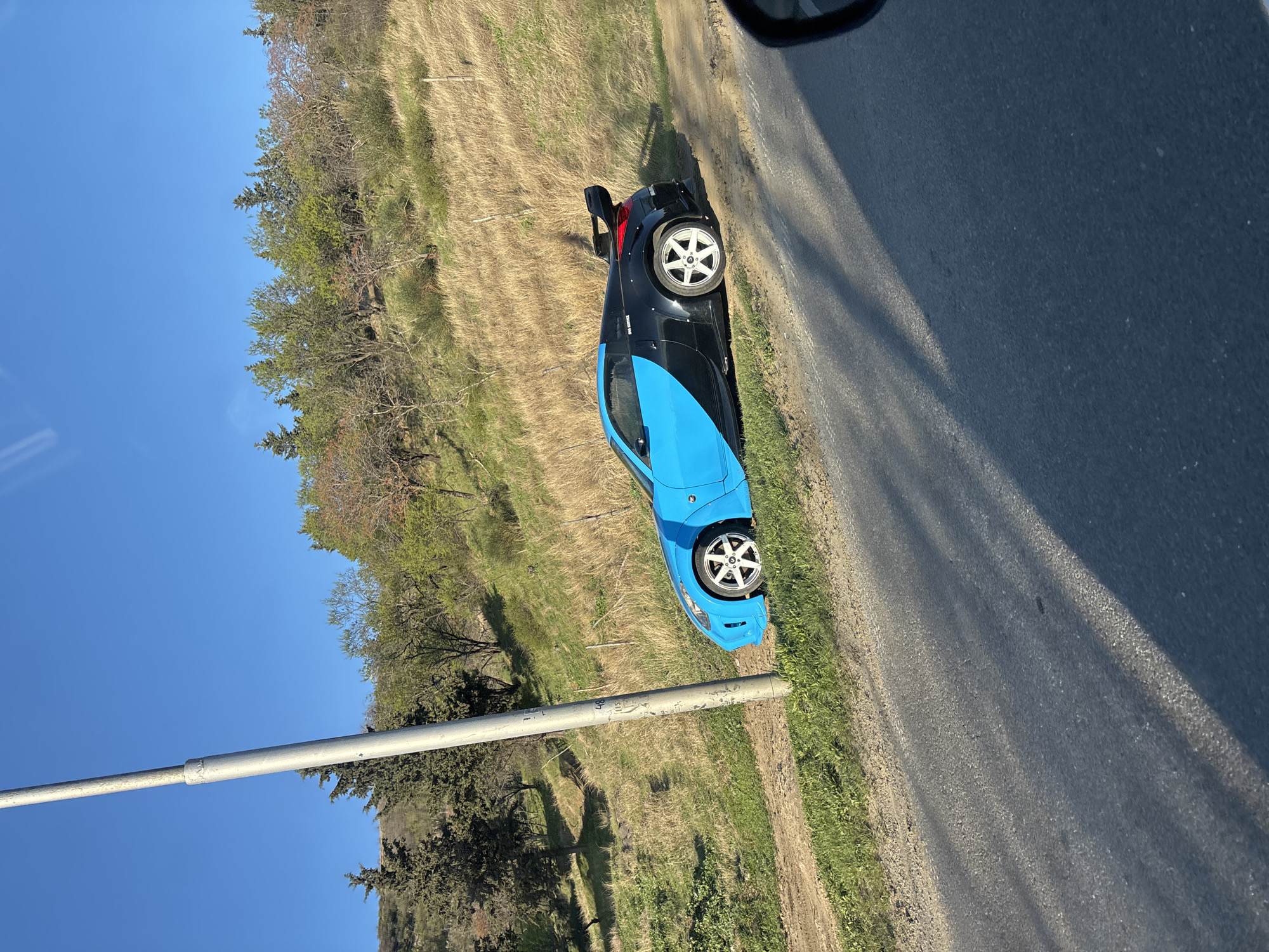 Sports car parked on roadside grass in Tbilisi hillside