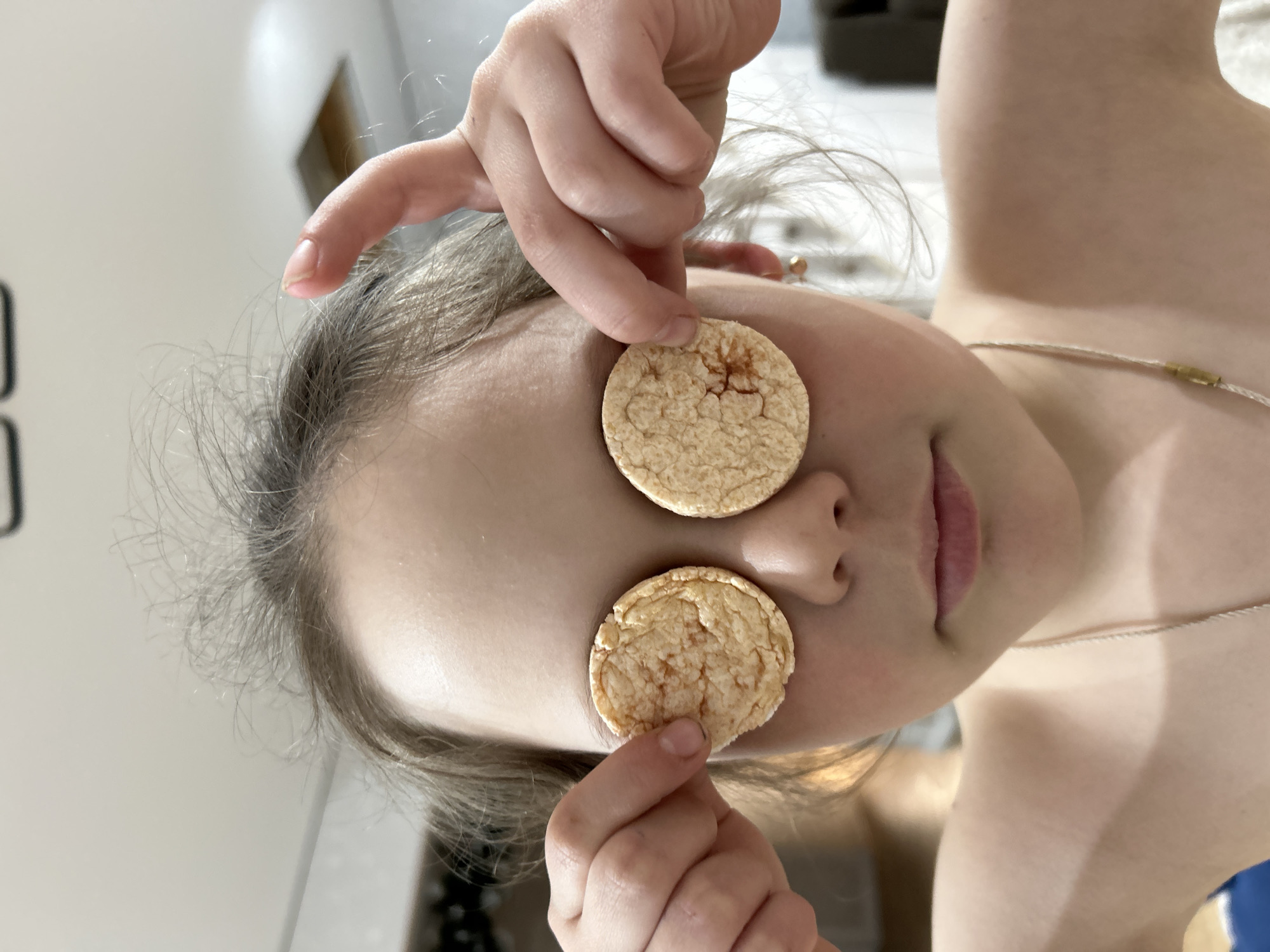 Child plays with rice crisps during photo session in Chaikovsky