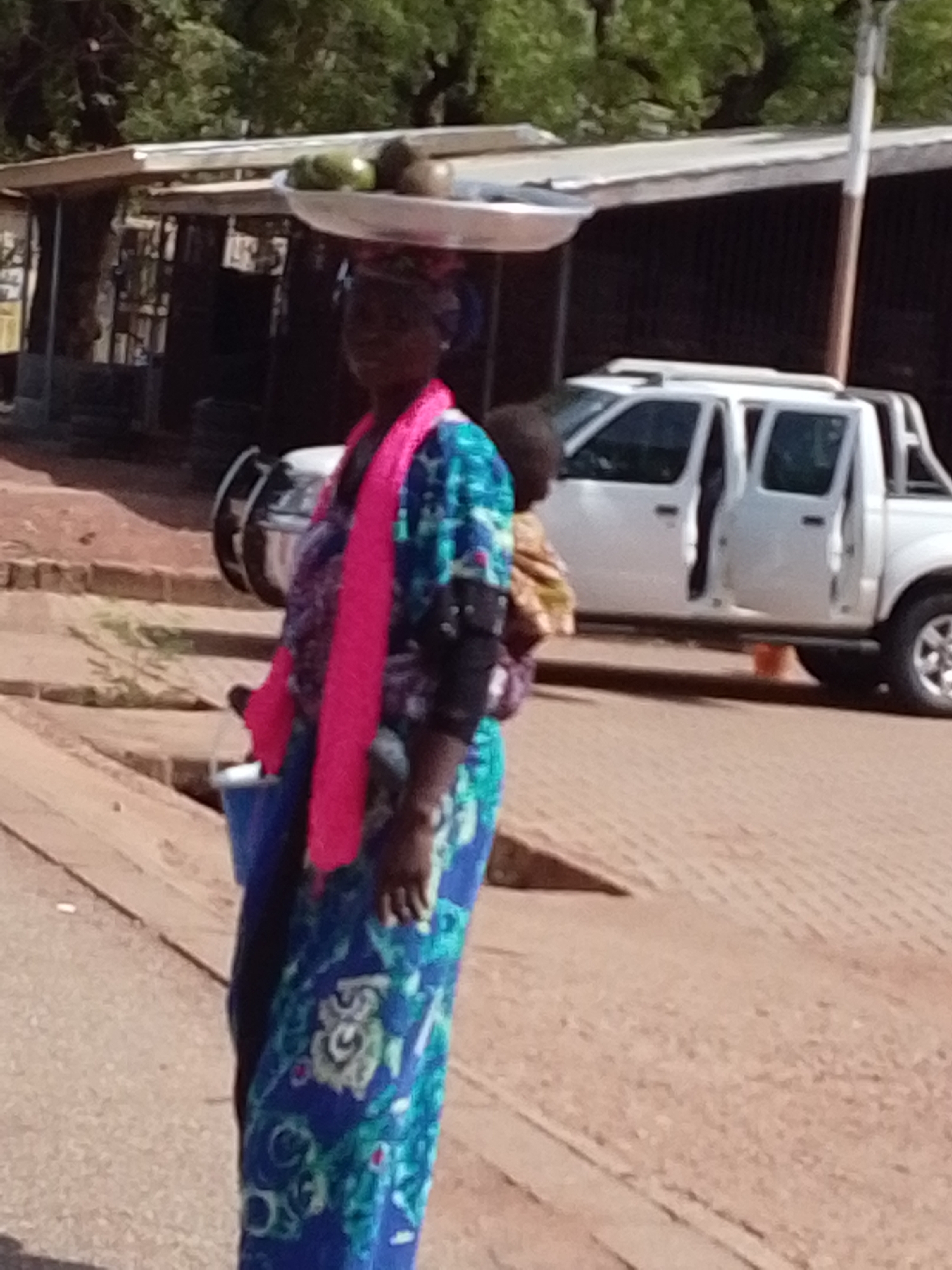 Women carry goods on heads in Tamale street scene