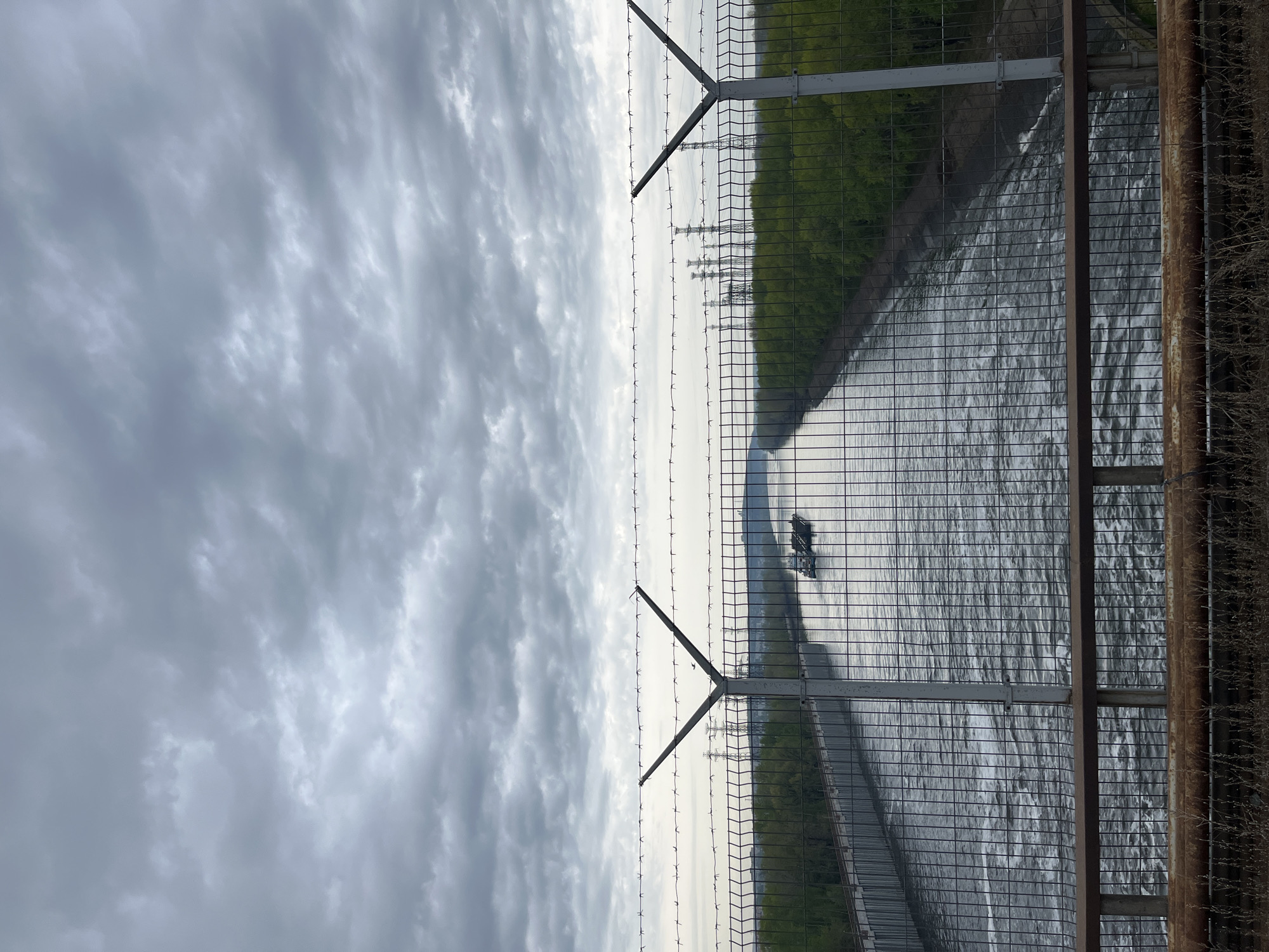 Fenced waterway view captured in Chaikovsky, Russia early morning