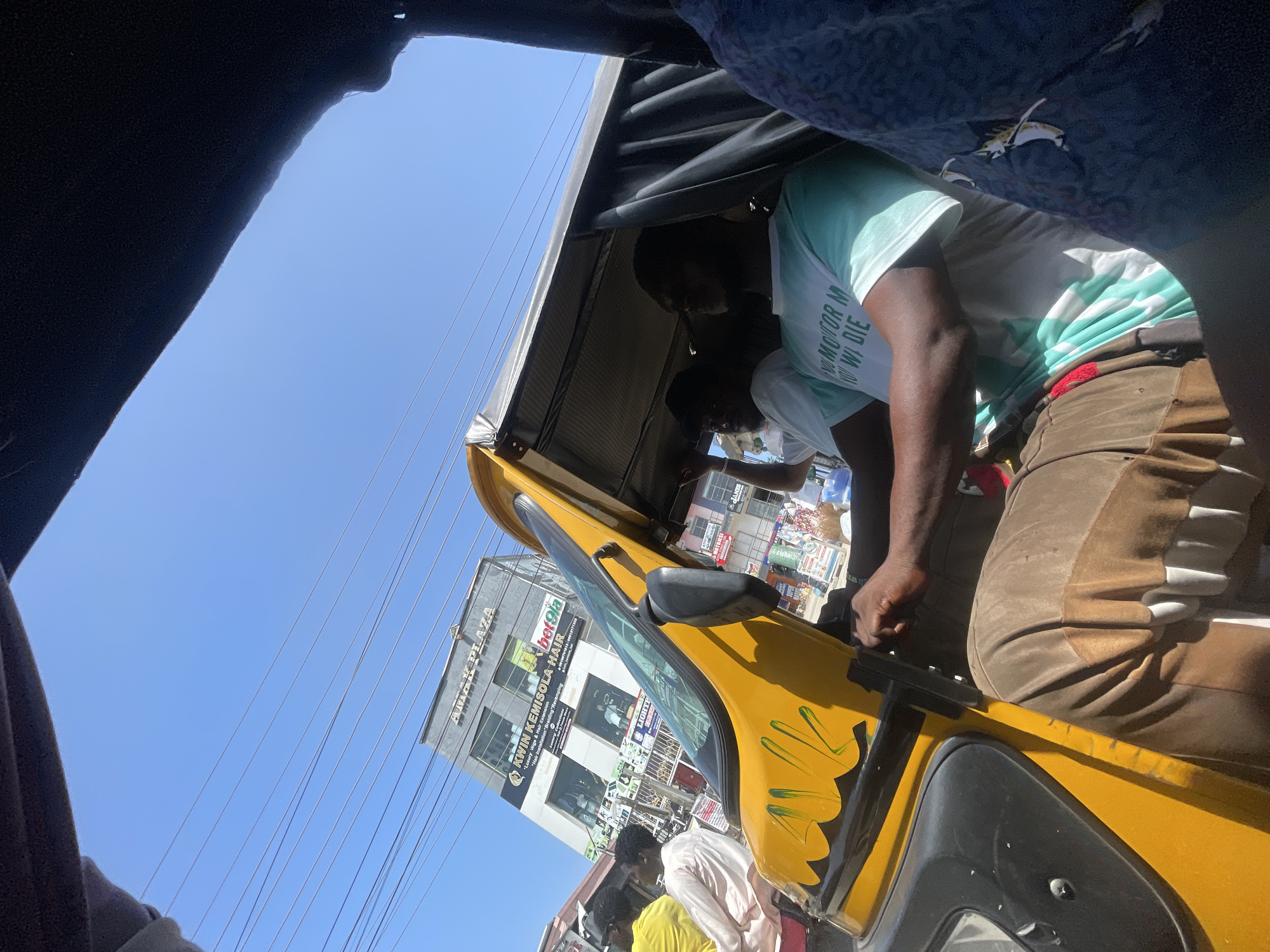 Passenger view from yellow auto-rickshaw captured in Ado, Nigeria