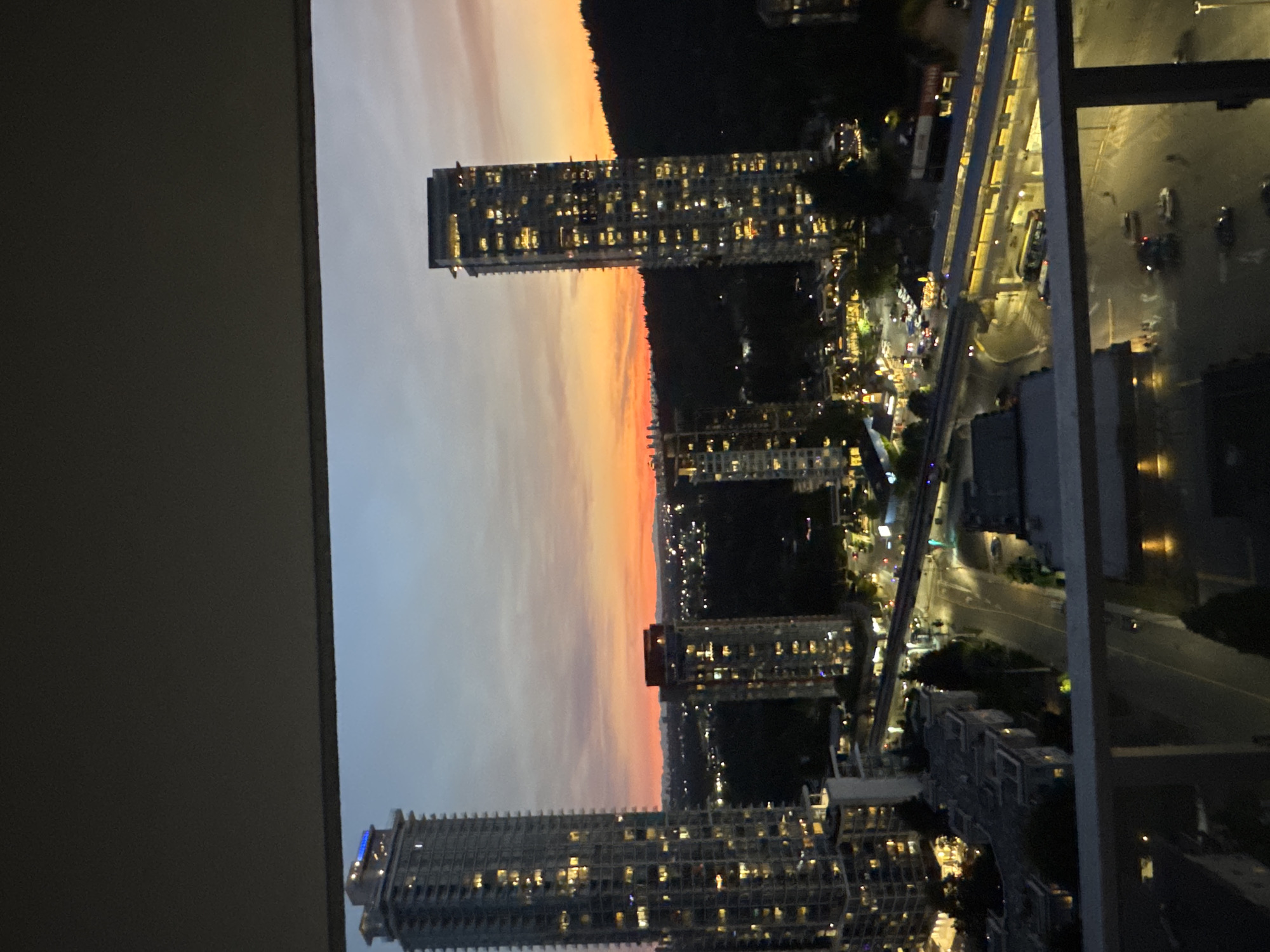 Coquitlam skyline glows at dusk from a balcony view