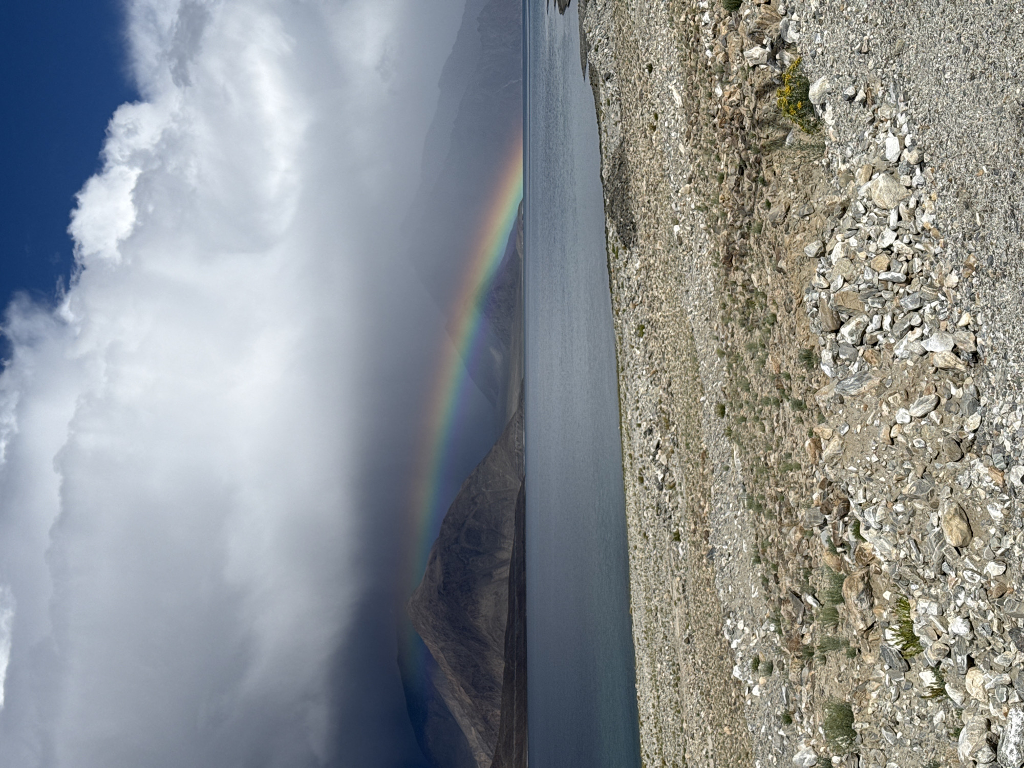 Rainbow over Pangong Tso lake with mountain backdrop