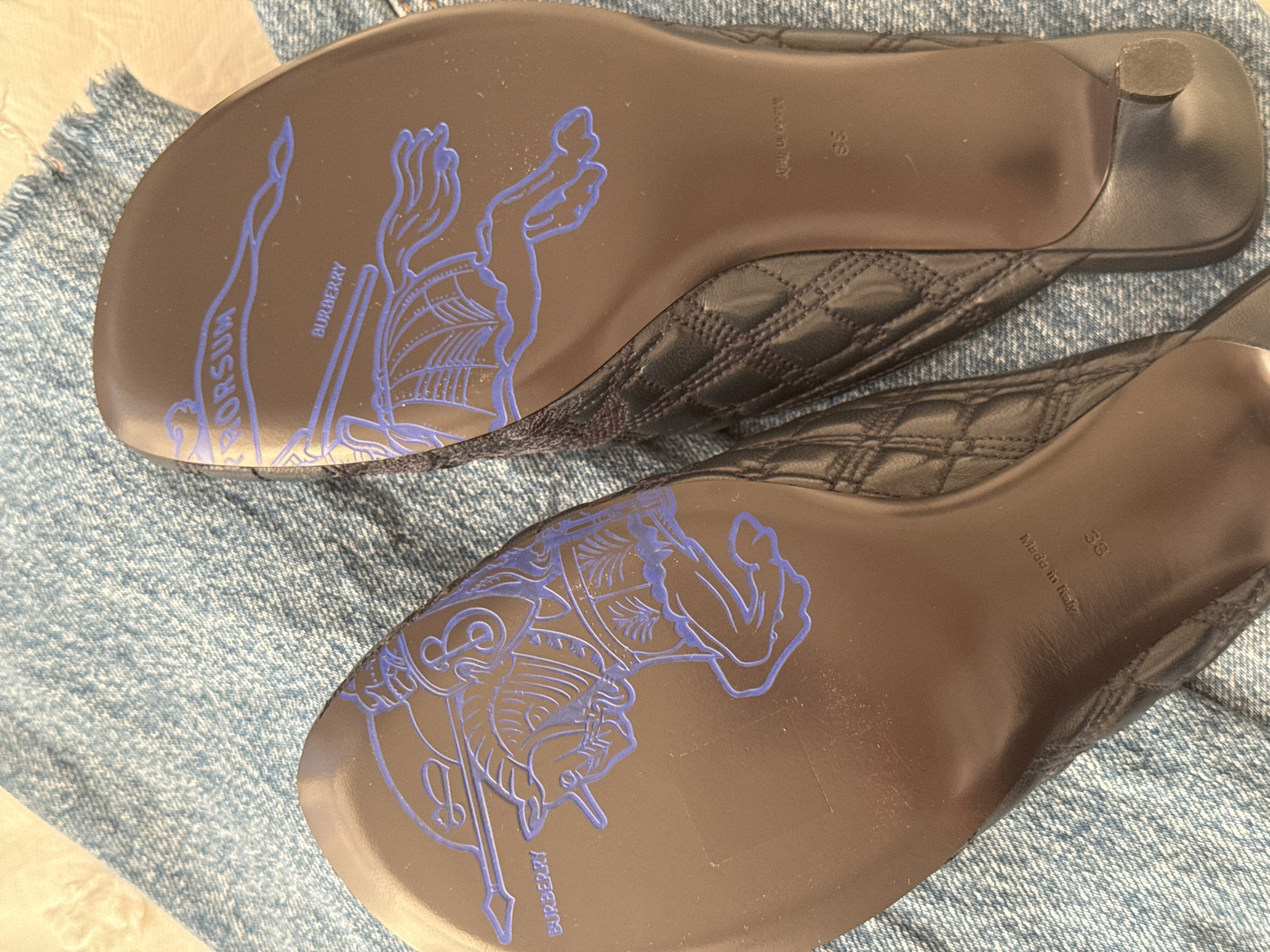 Burberry mules photographed showing brand logo and knight design