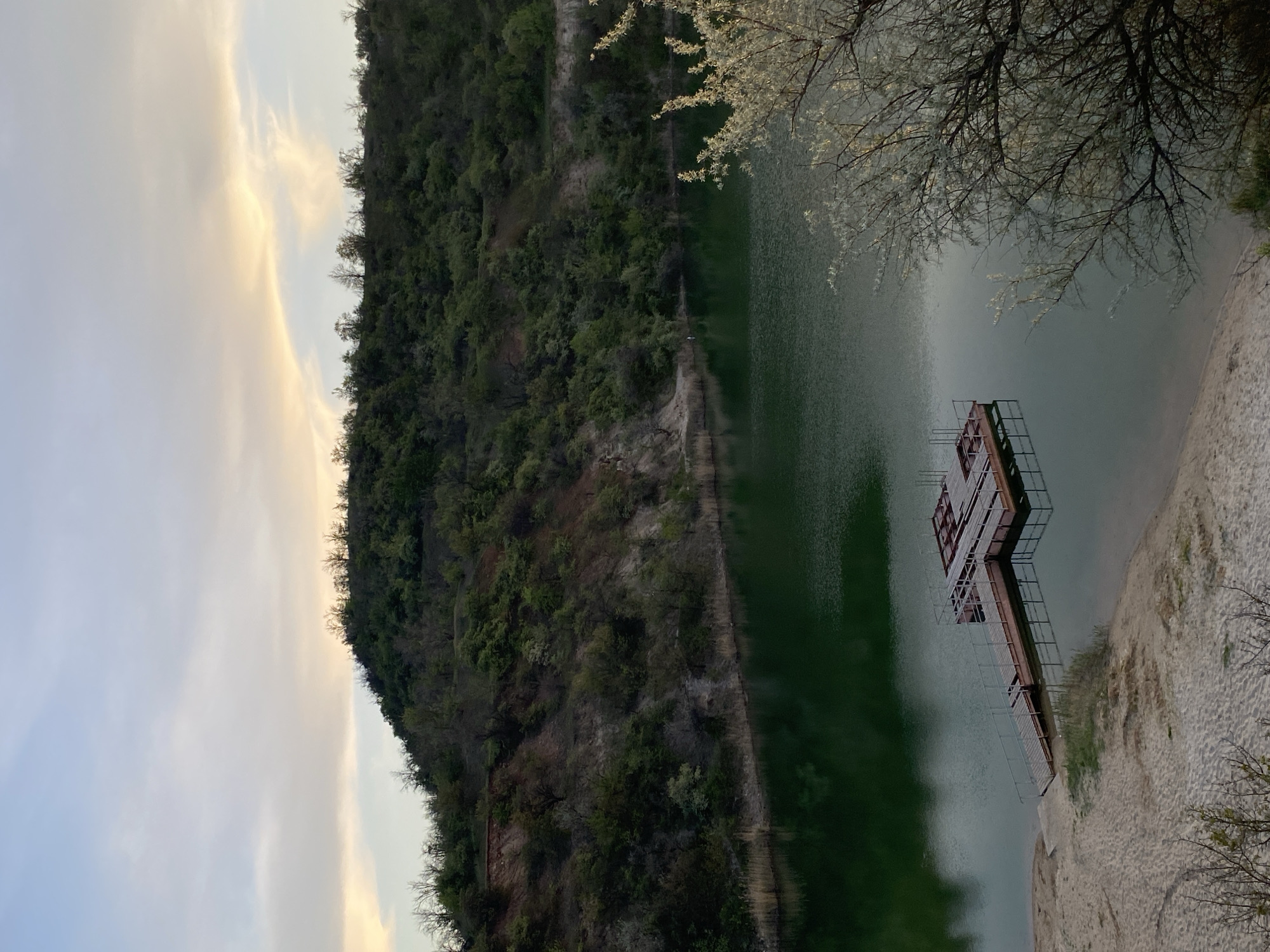 Lake sunset scene photographed with dock and hillside backdrop