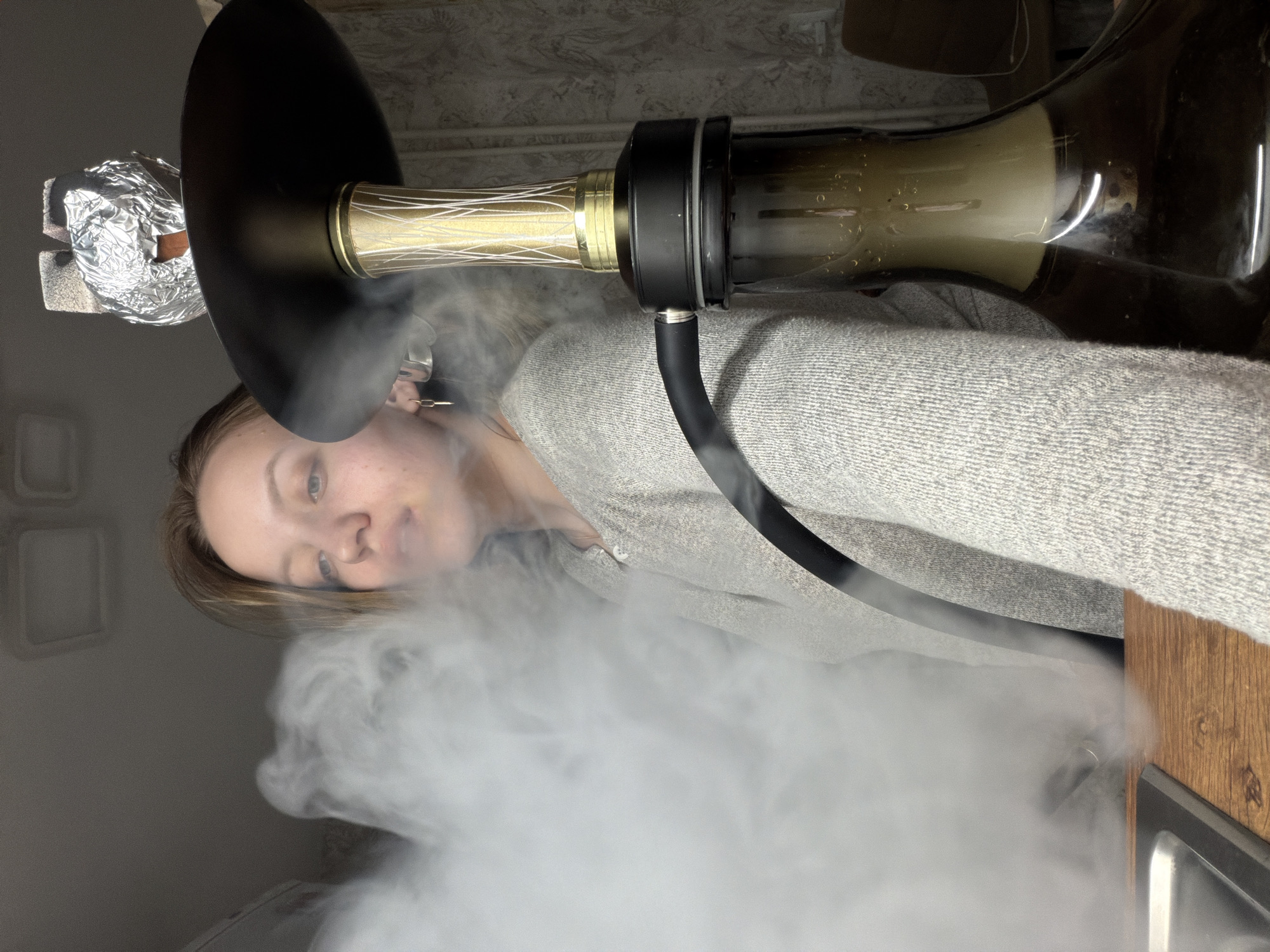 Woman smoking hookah indoors captured in Reshetnikovo, Russia