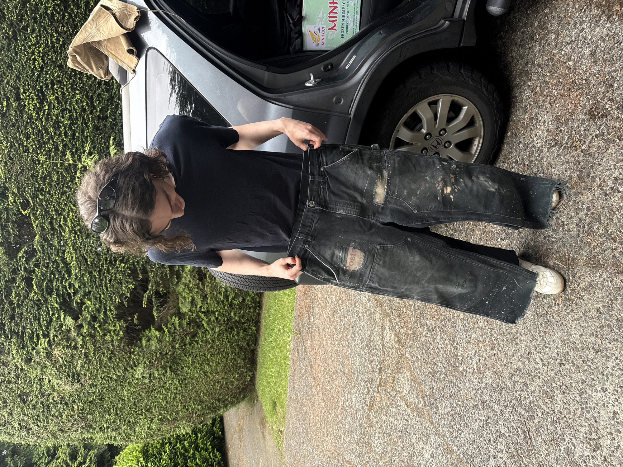 Person handles clothing at vehicle trunk in North Vancouver