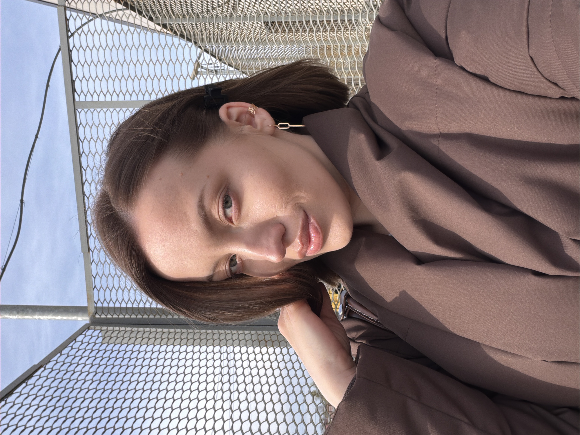 Woman photographed smiling near fence in Reshetnikovo, Russia