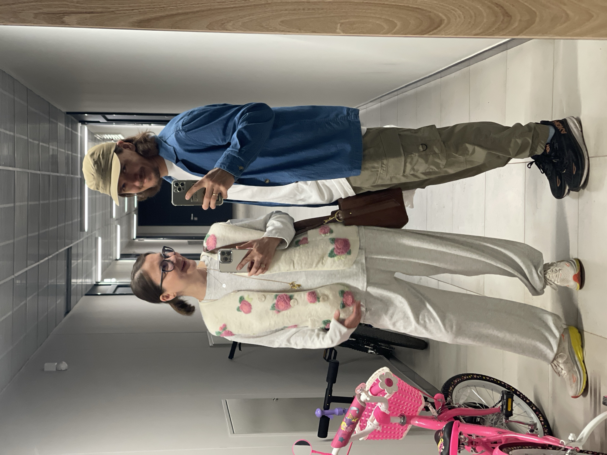 Two people captured in hallway mirror selfie