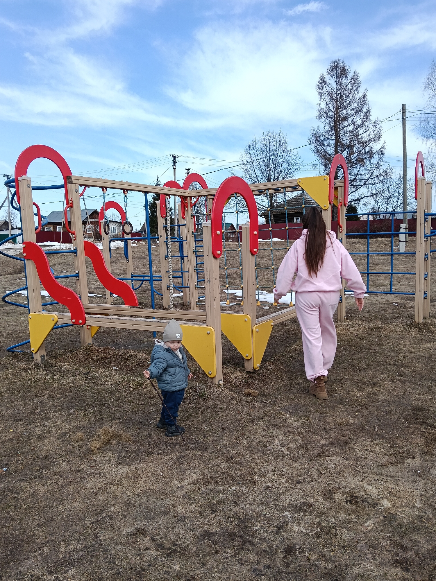 Woman and child at playground in early spring Russia