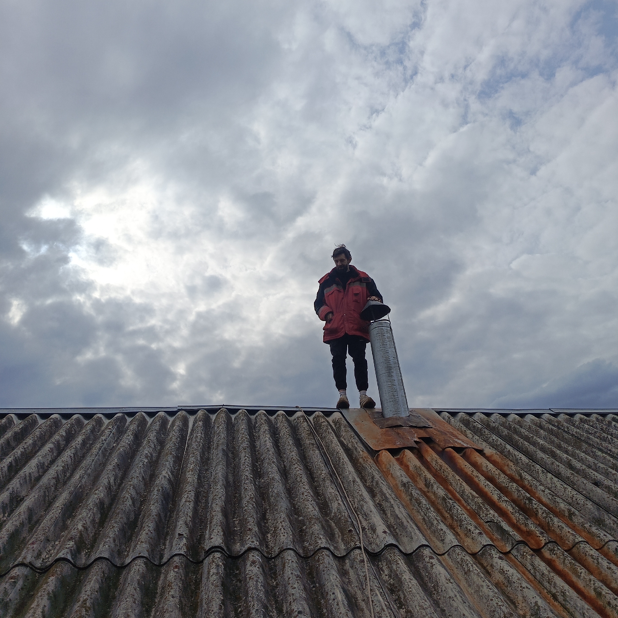 Person stands on corrugated roof in Svoboda, Russia