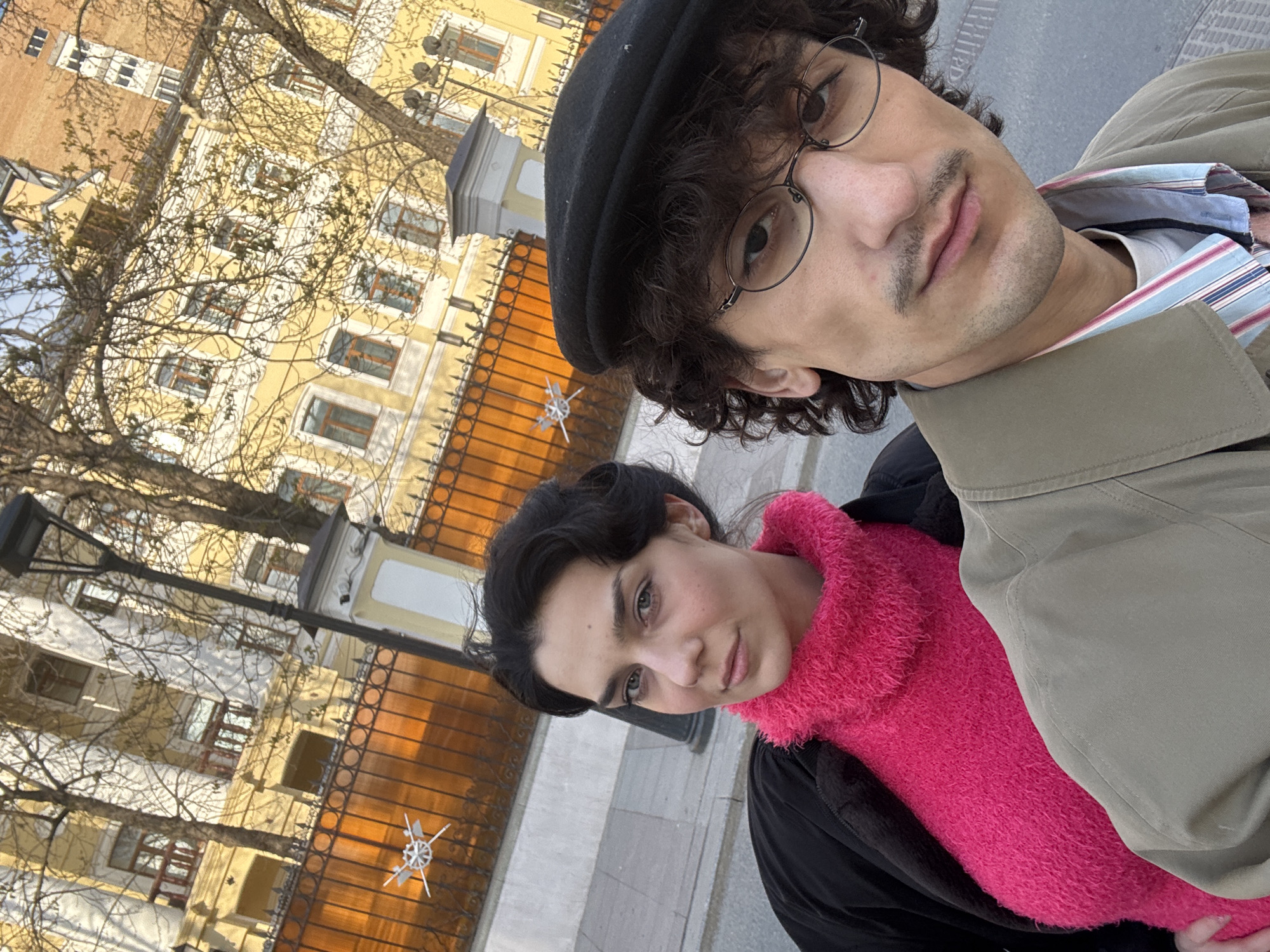 Two people take selfies on Moscow sidewalk