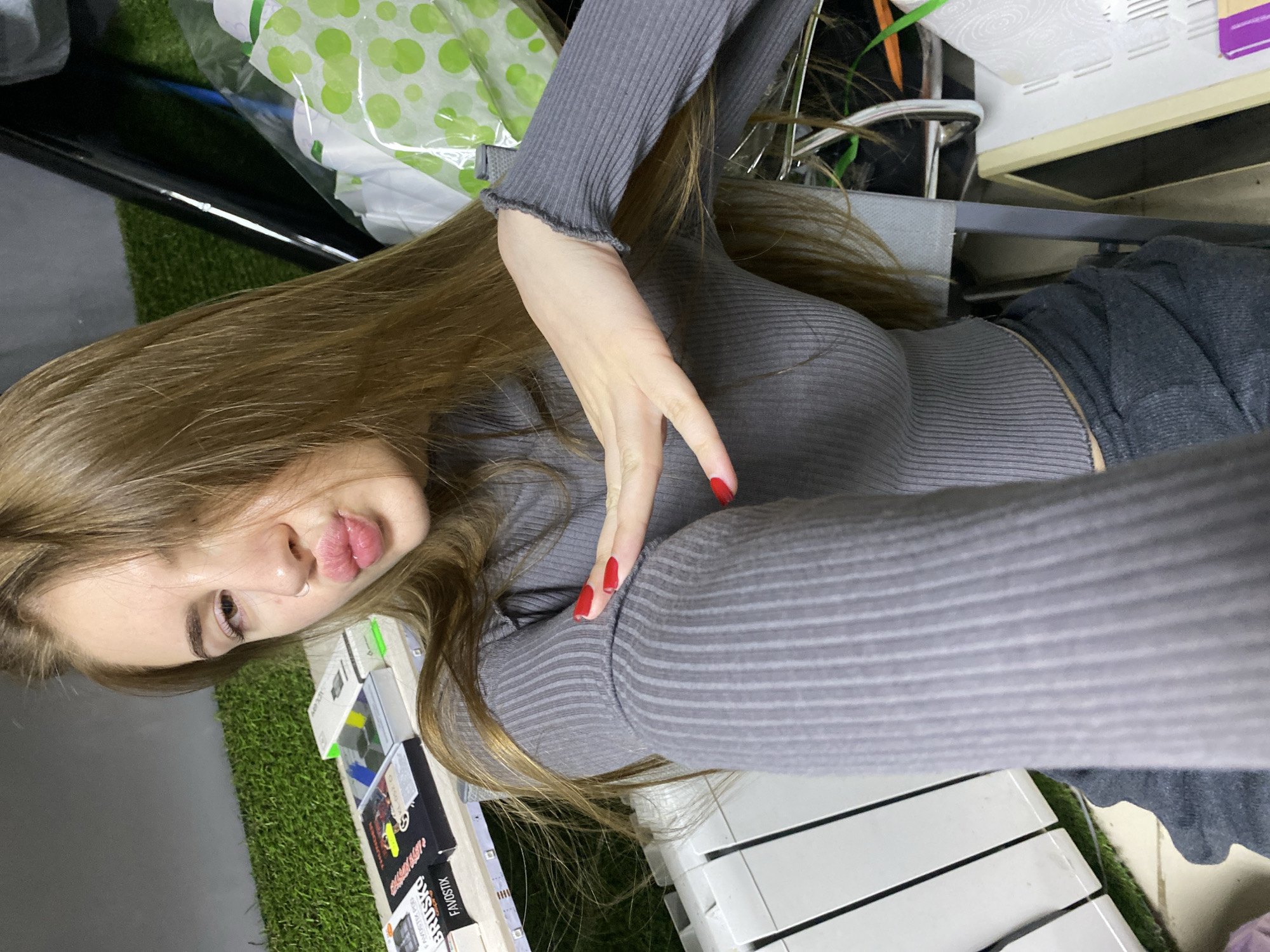 Woman takes selfies in grey sweater in Russian village