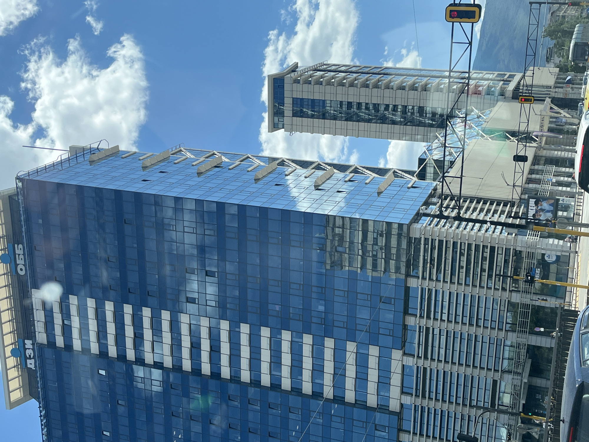 Glass skyscrapers rise against a bright blue sky
