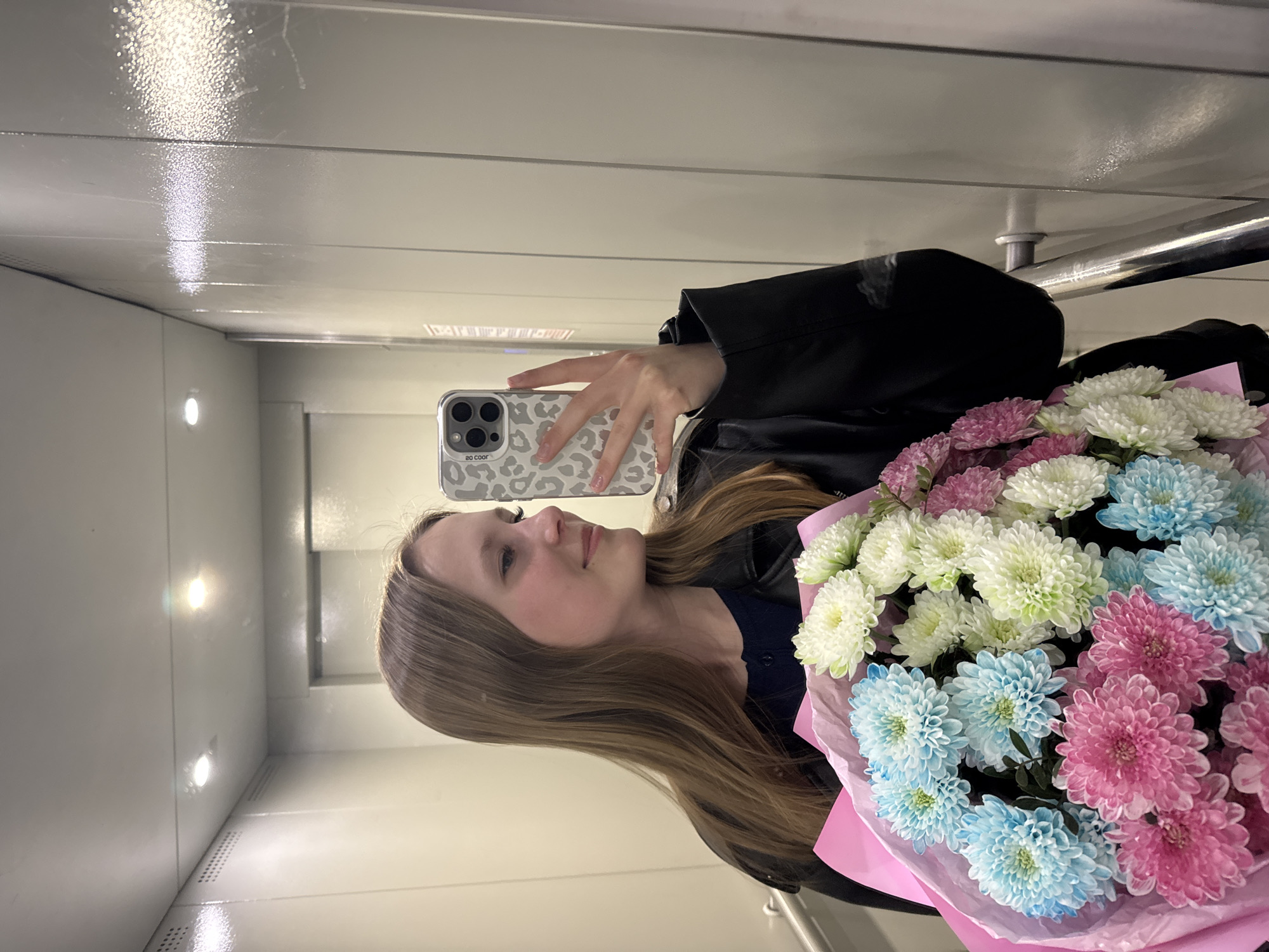 Woman takes flower bouquet selfie in Chaikovsky elevator