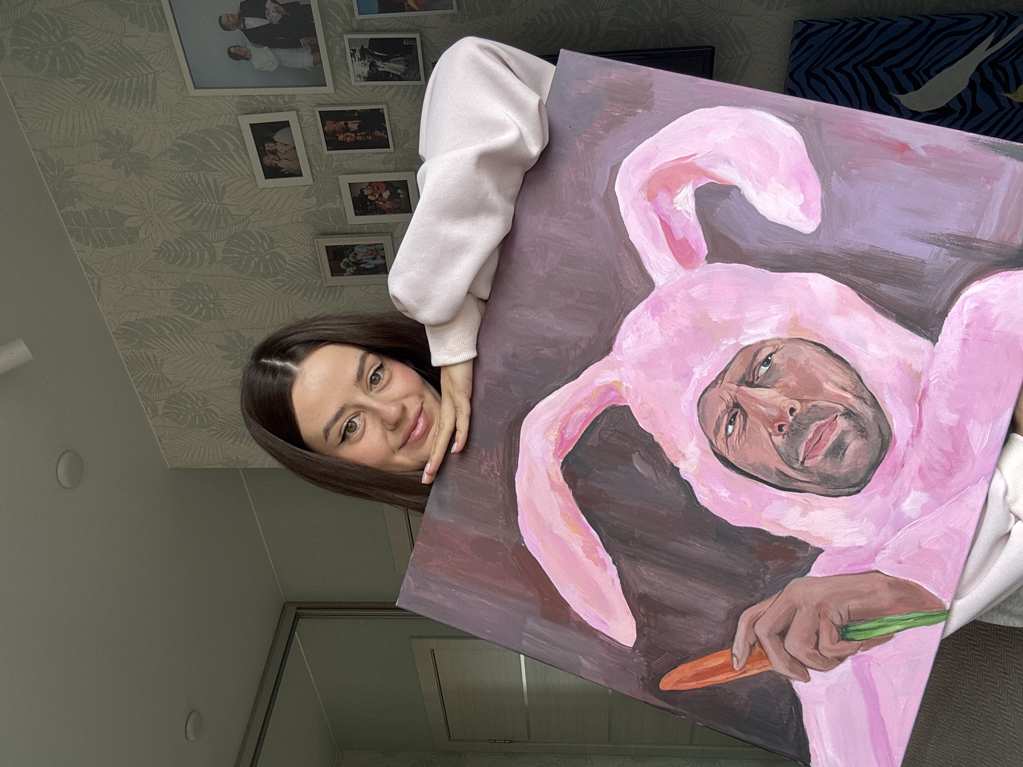 Woman displays quirky bunny painting in Krasnoyarsk apartment selfie session