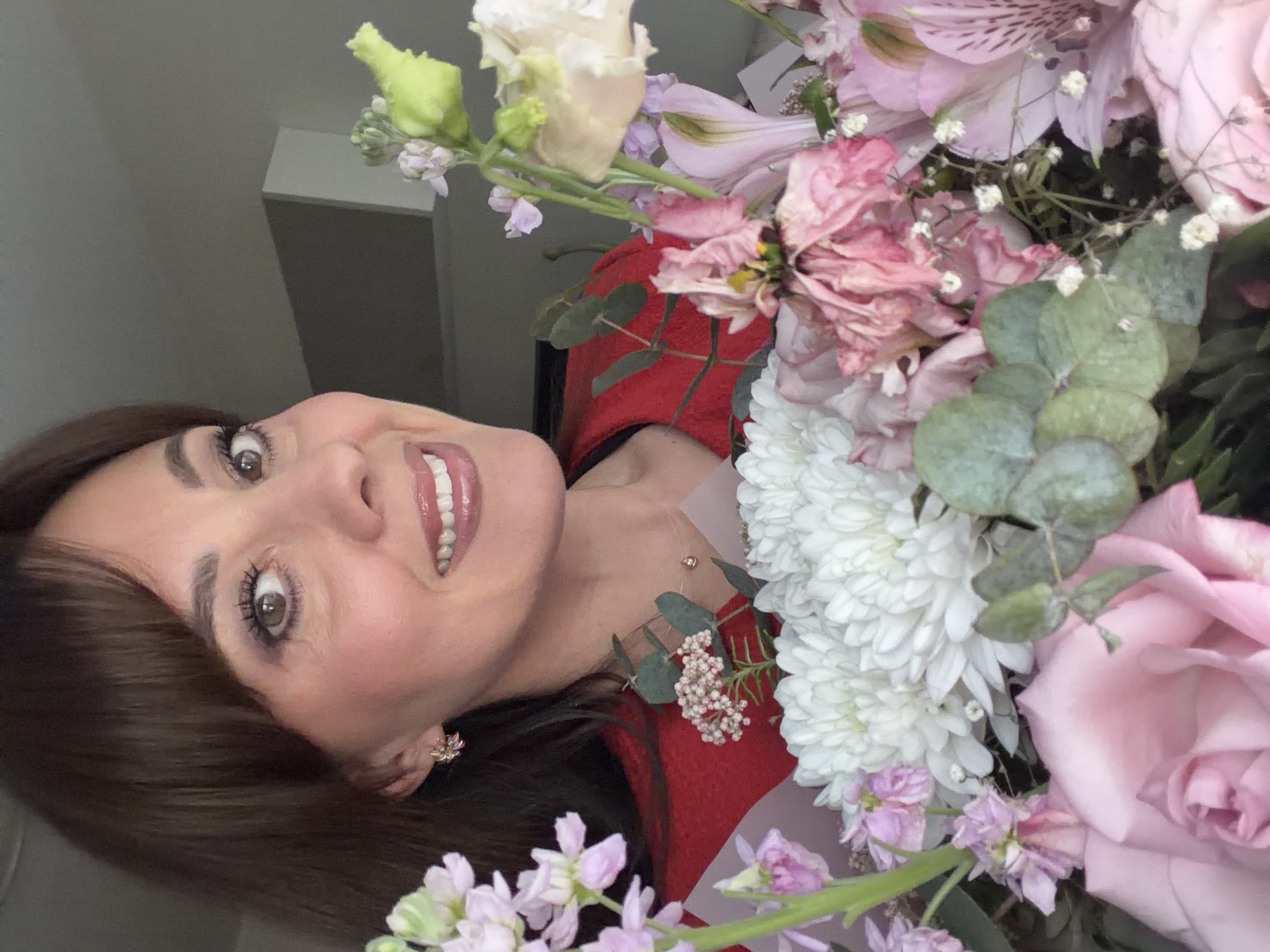 Woman poses with flowers, applies makeup in Riga afternoon