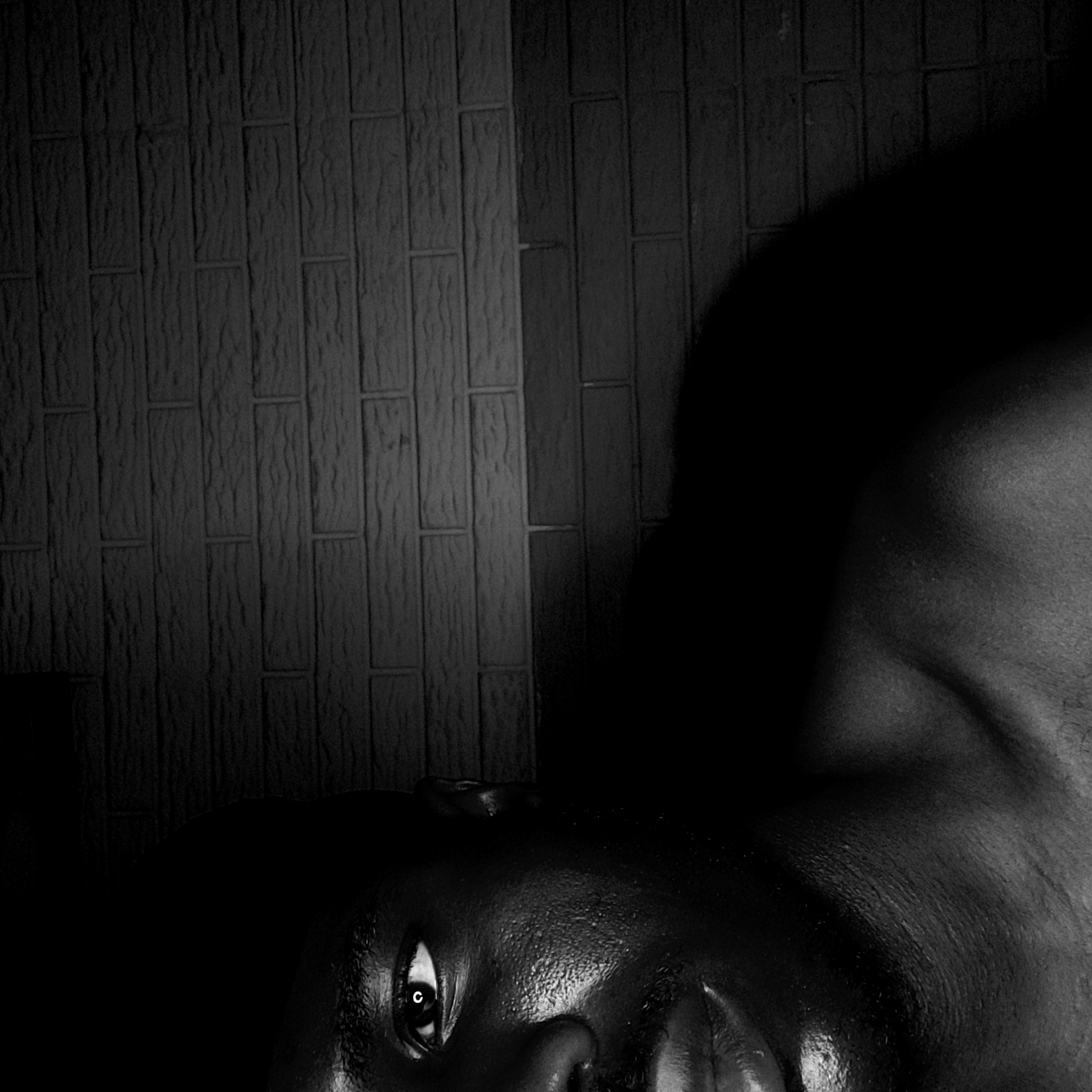 Person photographed resting near wall in Narayi, Nigeria