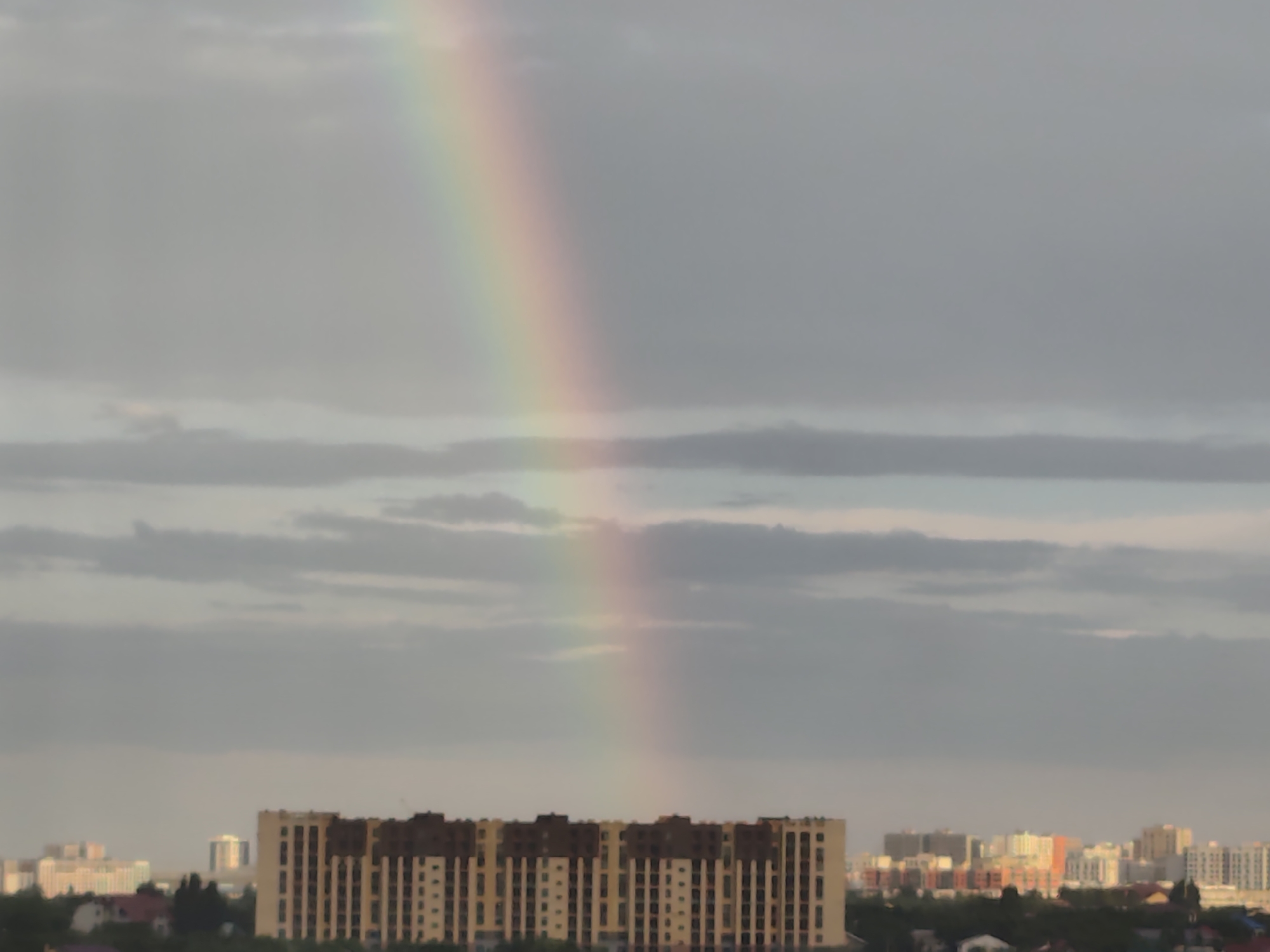 Rainbow over a cloudy city skyline