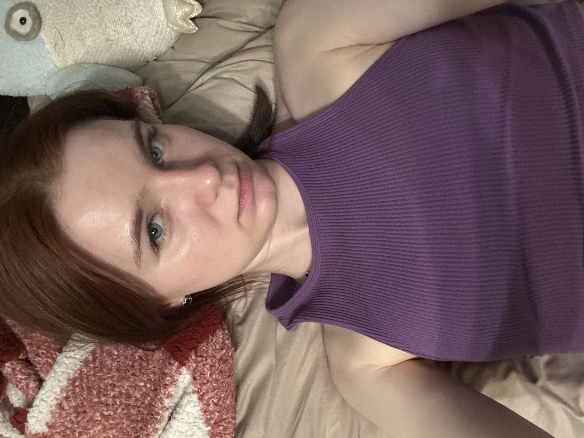 Woman rests on bed in Vsevolozhsk room