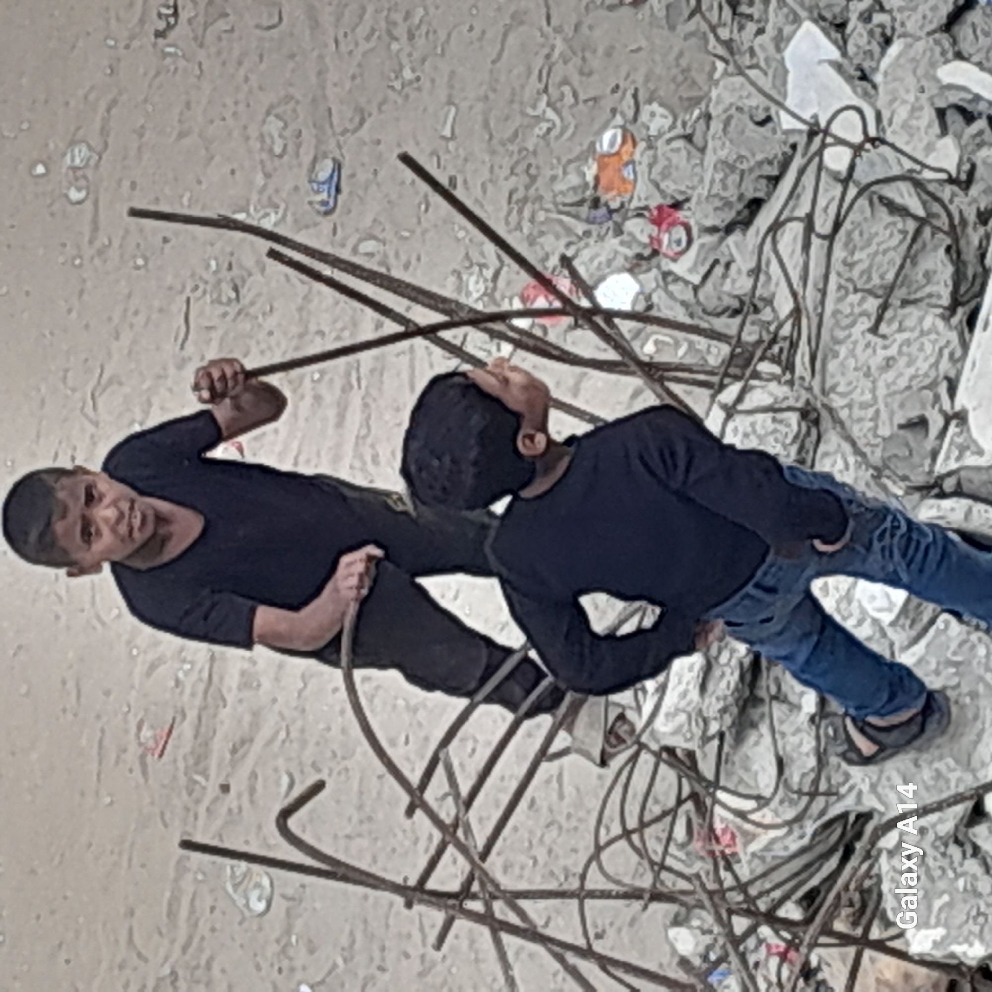 People navigate debris field amid twisted metal, rubble