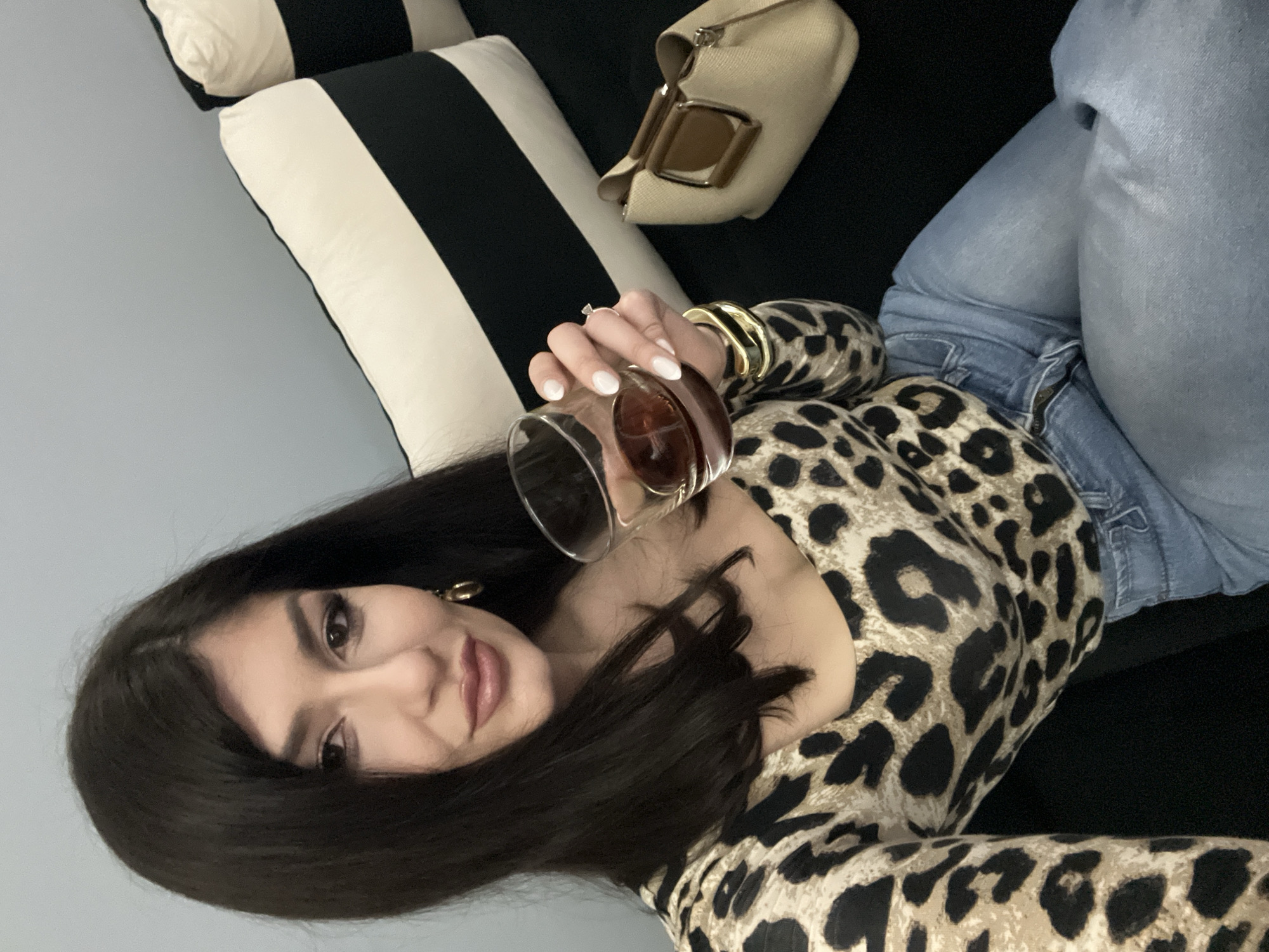 Woman with drink relaxes on sofa in Yambol