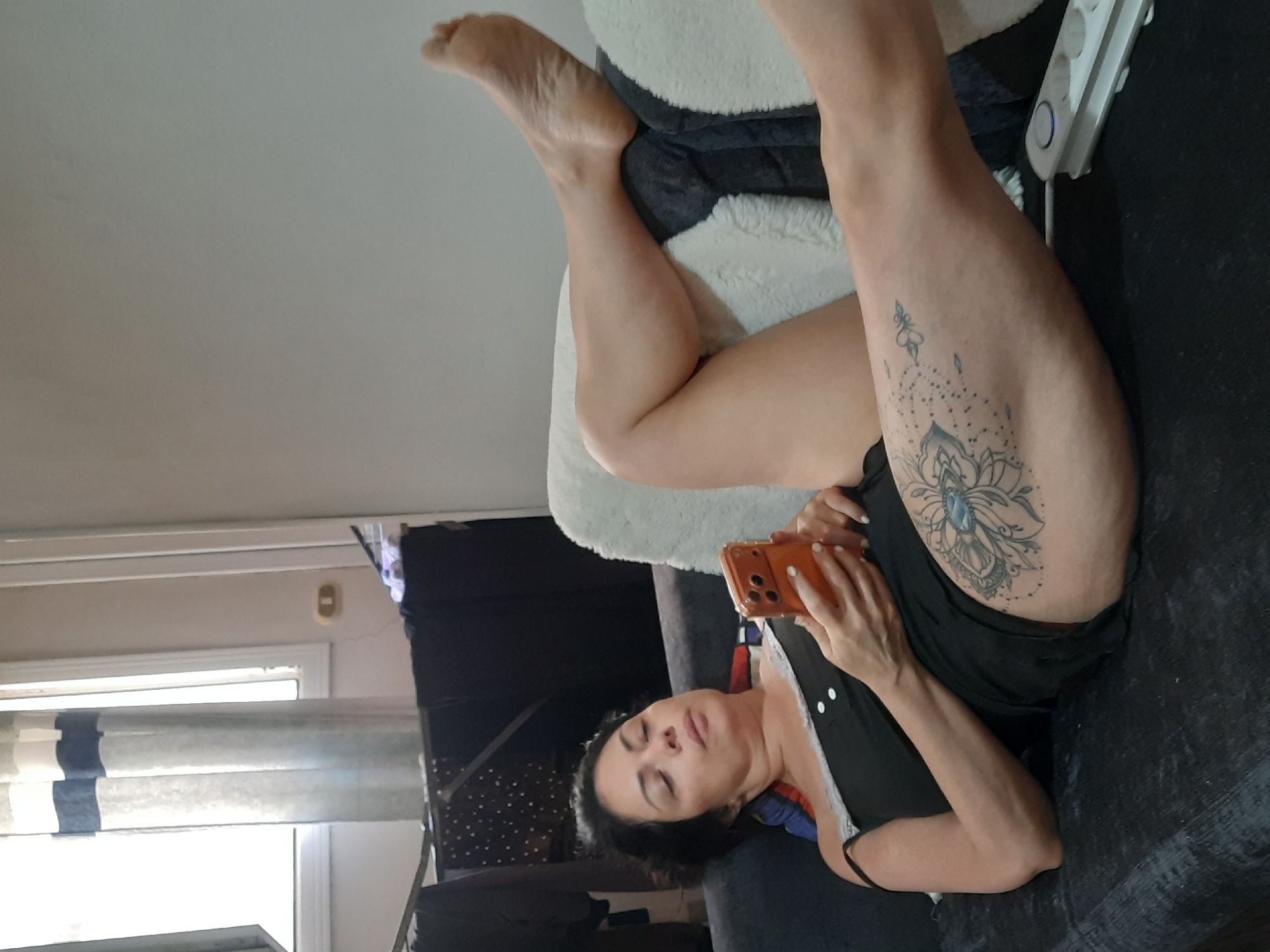 Woman rests on couch with phone in Al Hadaba