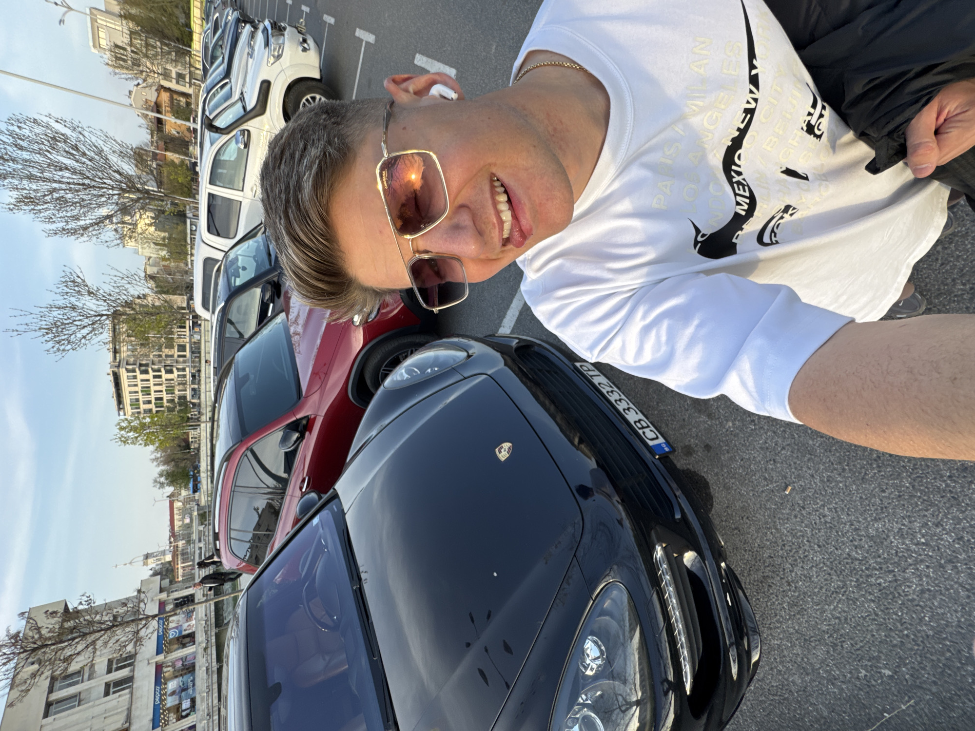 Man poses with luxury cars in Plovdiv parking area