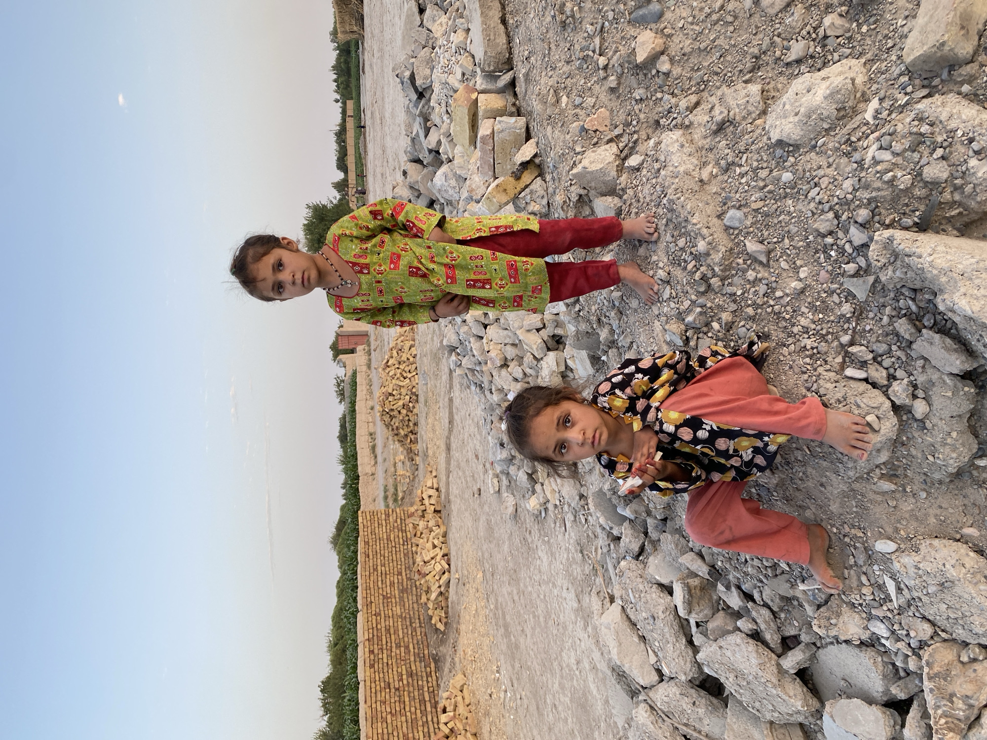 Children among rubble in Kandahar under open skies
