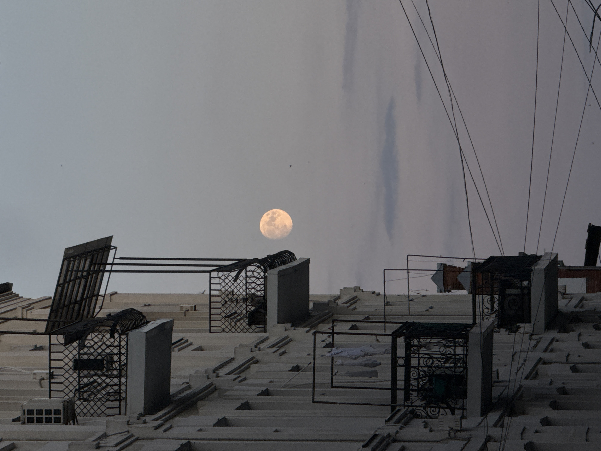Full moon rises over Vinnytsia balconies at dusk