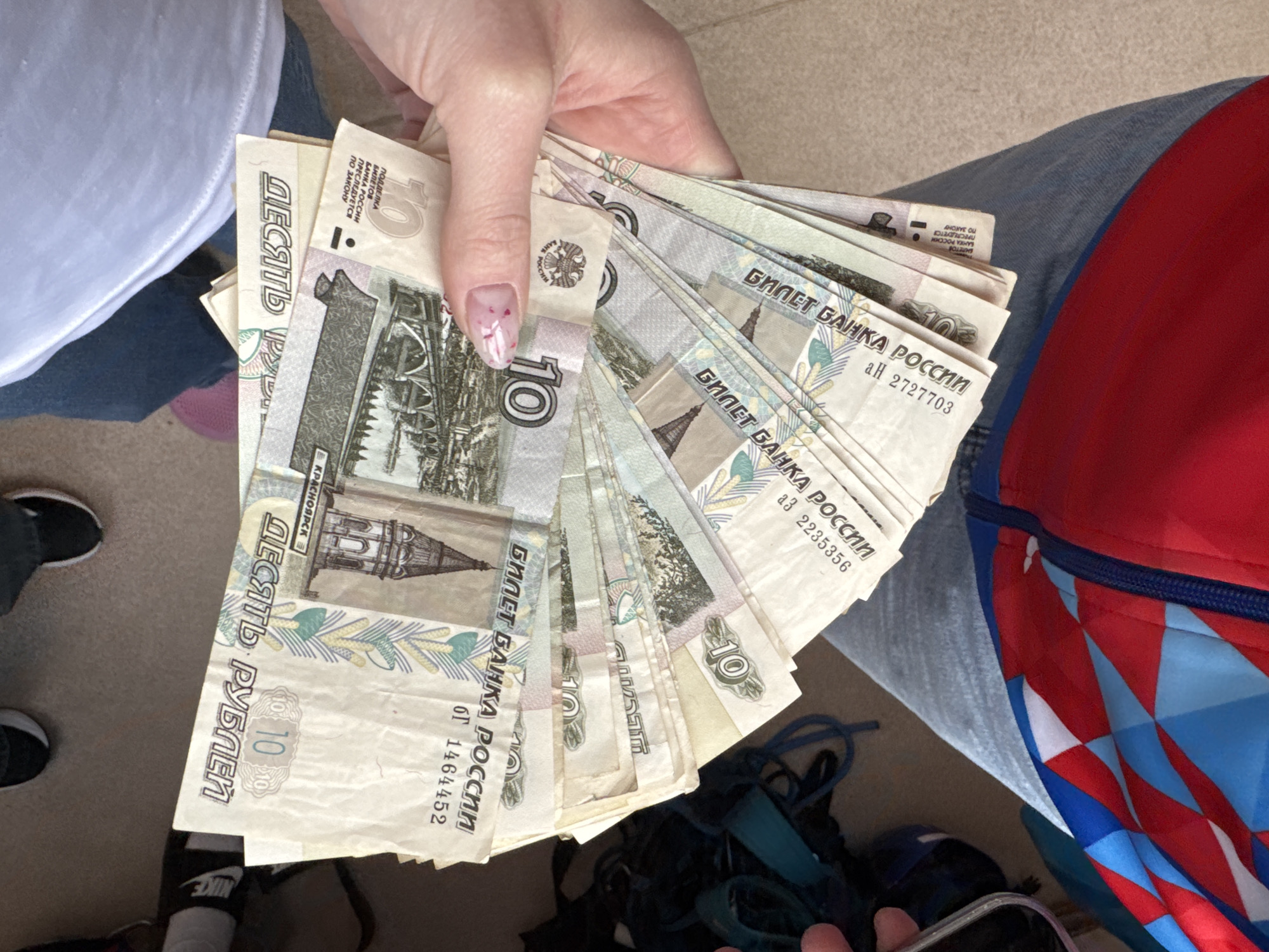 Person displays Russian banknotes in multiple photos in Usolye