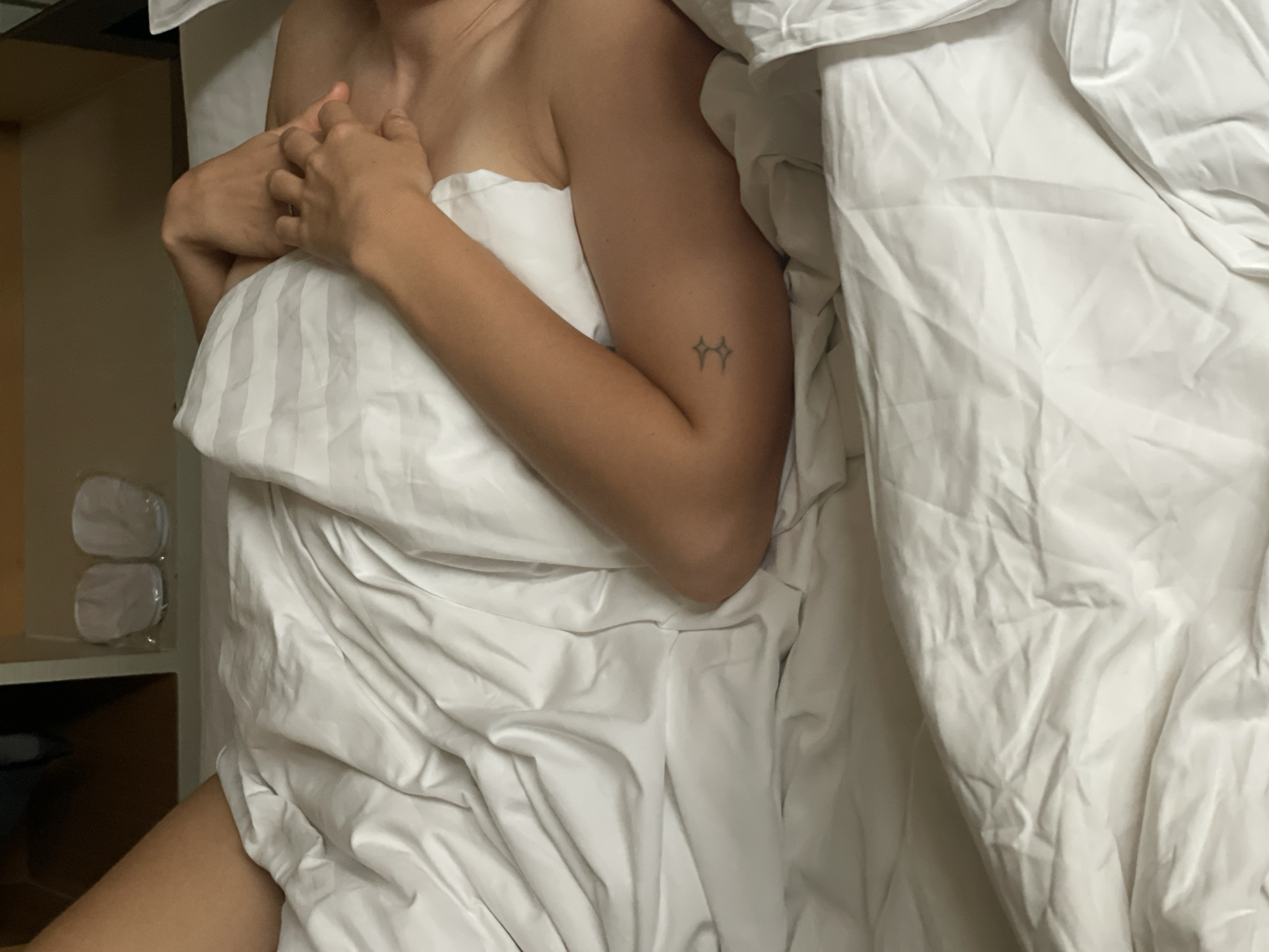 Person resting in Bangkok hotel room bed