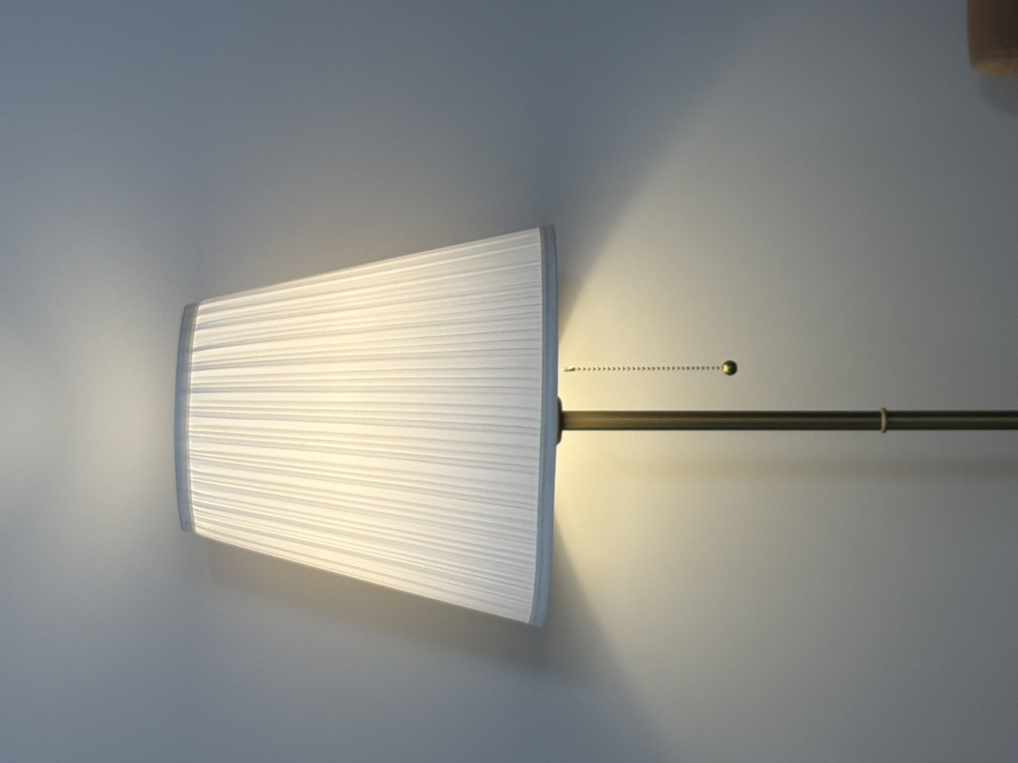 Wall lamp with white pleated shade documented in Moscow