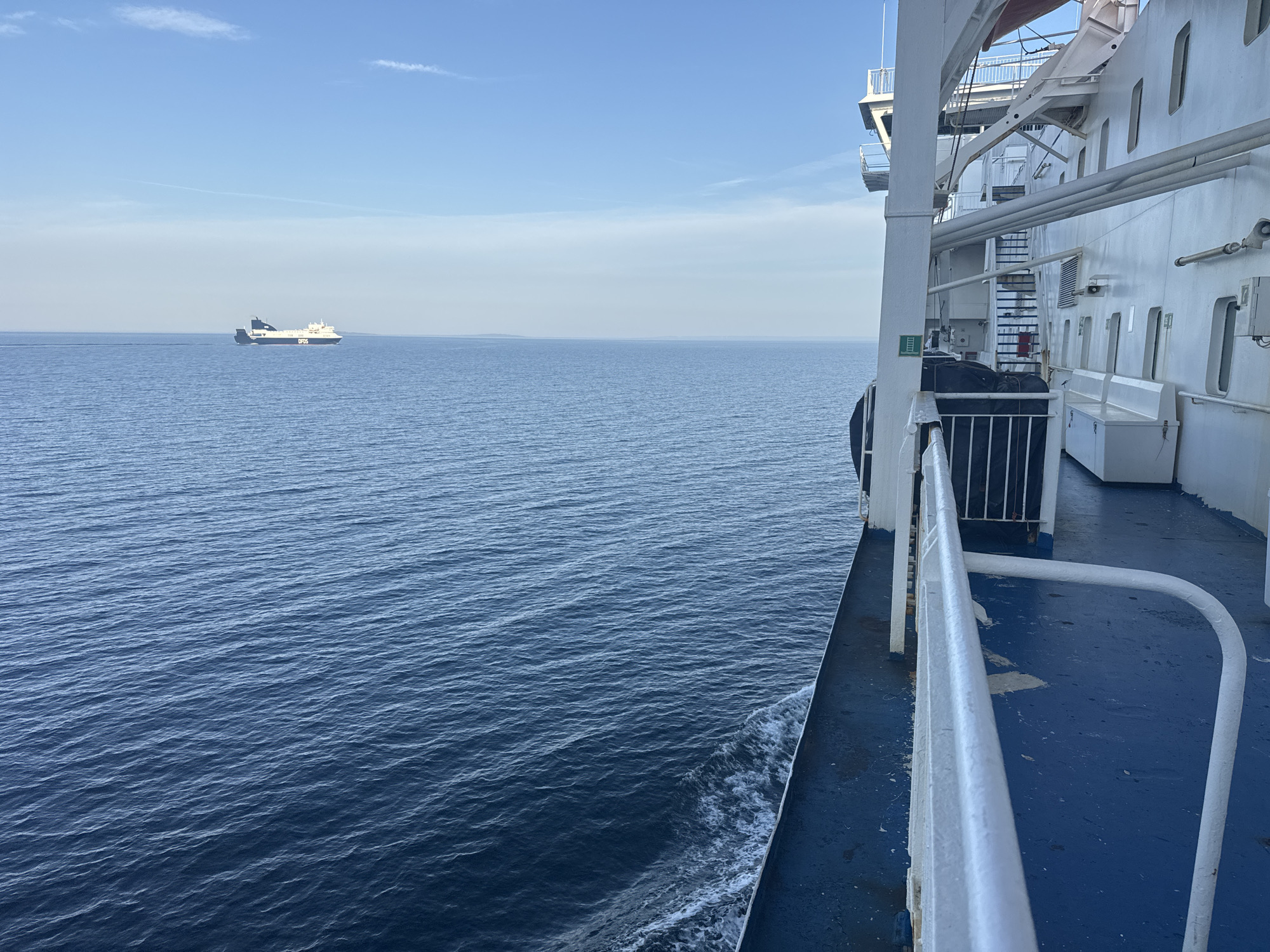 Two ferries share calm Swedish waters under a clear sky
