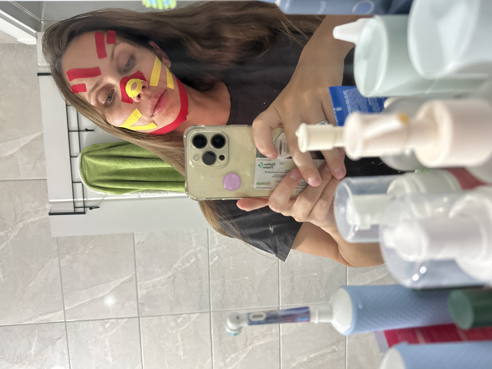 Woman applies kinesiology tape to face in Fethiye bathroom