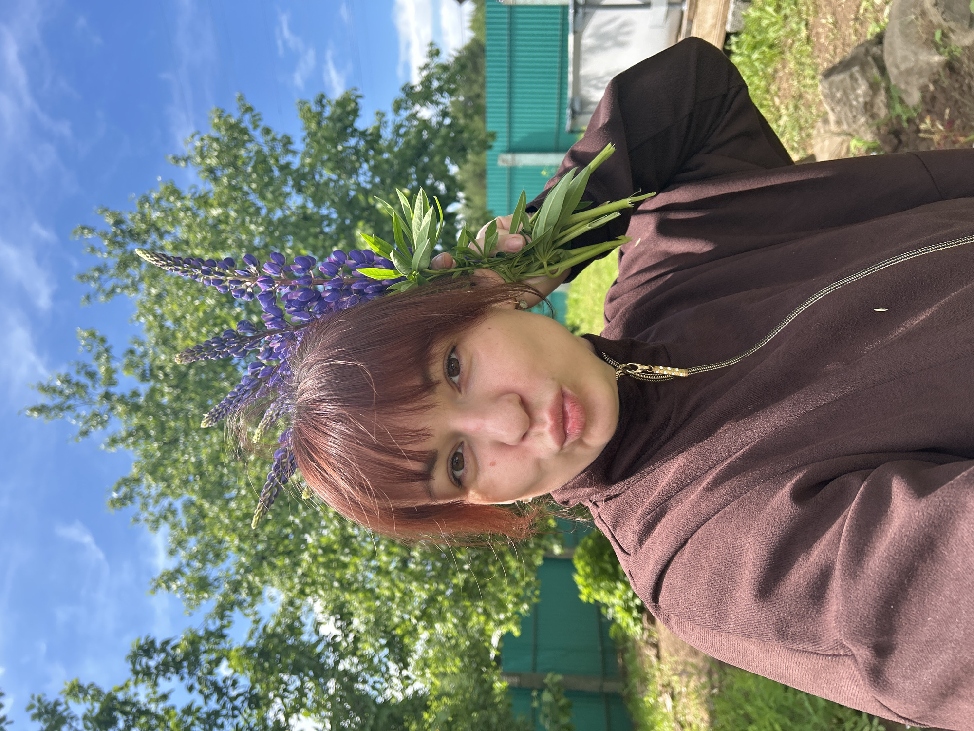 Woman poses with purple lupine bouquet in Russian countryside
