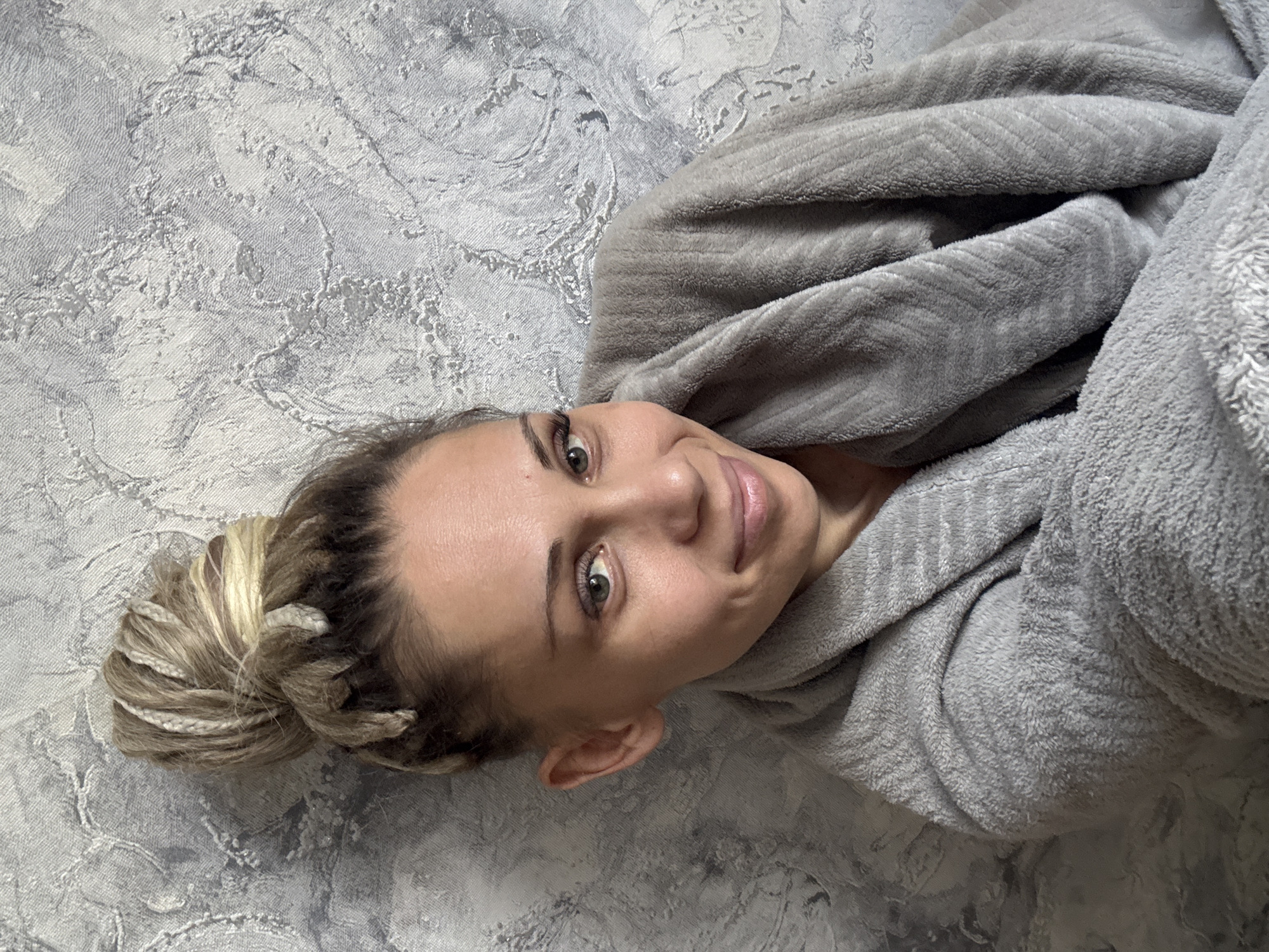 Woman rests in gray robe in Zavolzhye, Russia