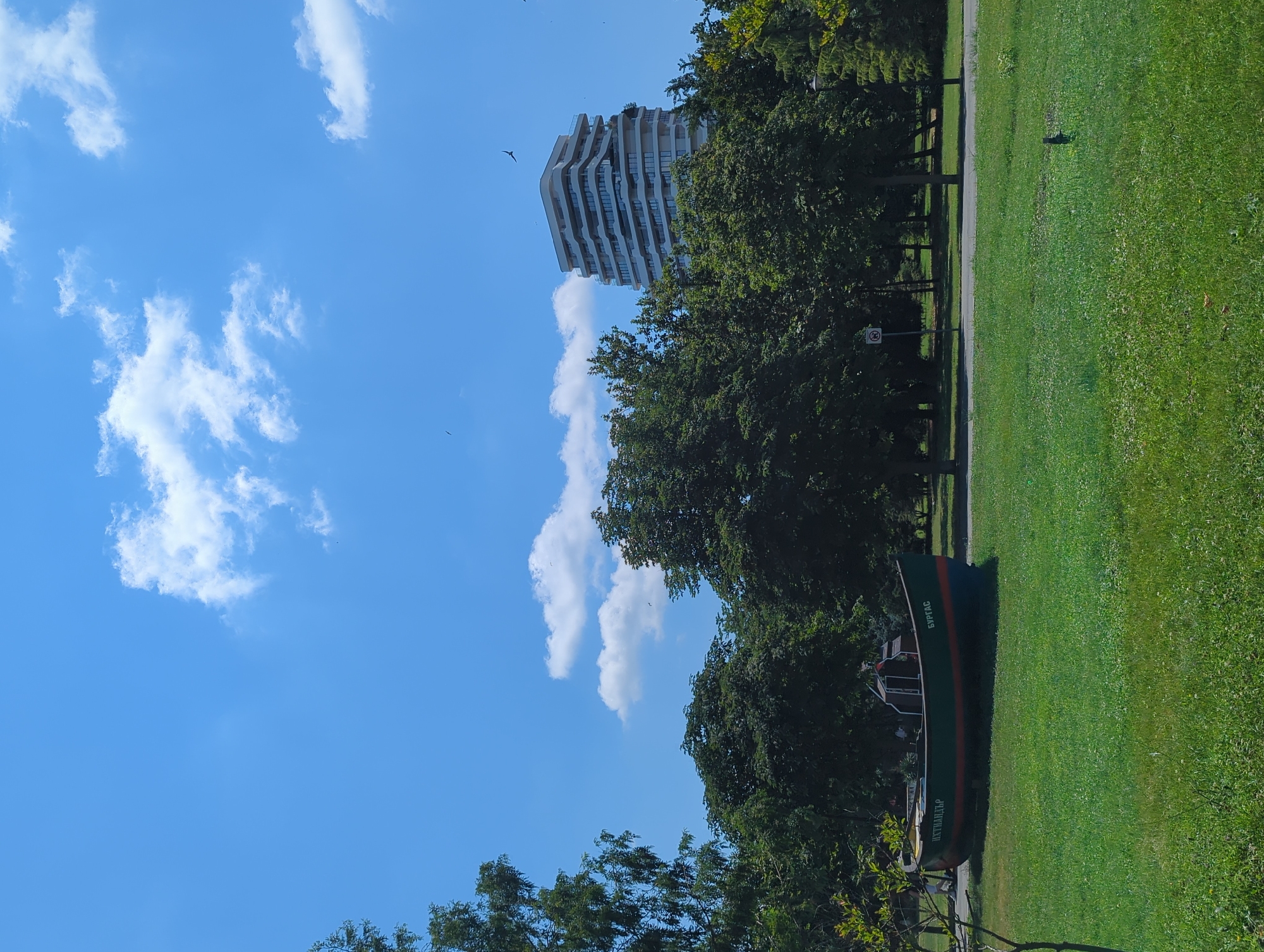 Fishing boat display and parked cars in an urban park setting