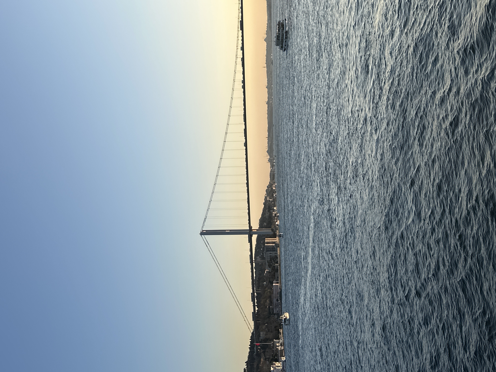 Bosphorus suspension bridge observed with boat traffic in Istanbul