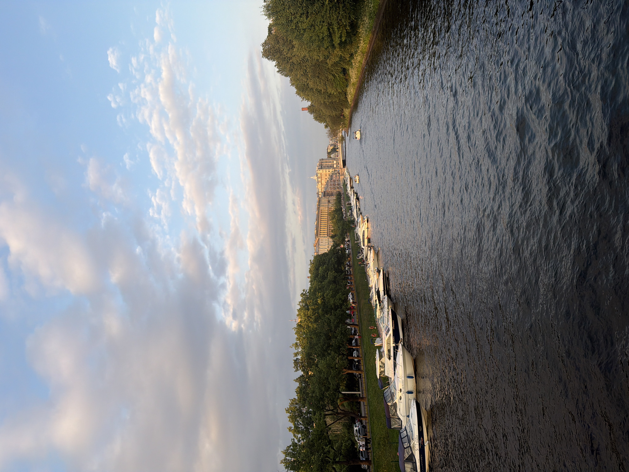 Golden hour along a city waterfront with boats and river views
