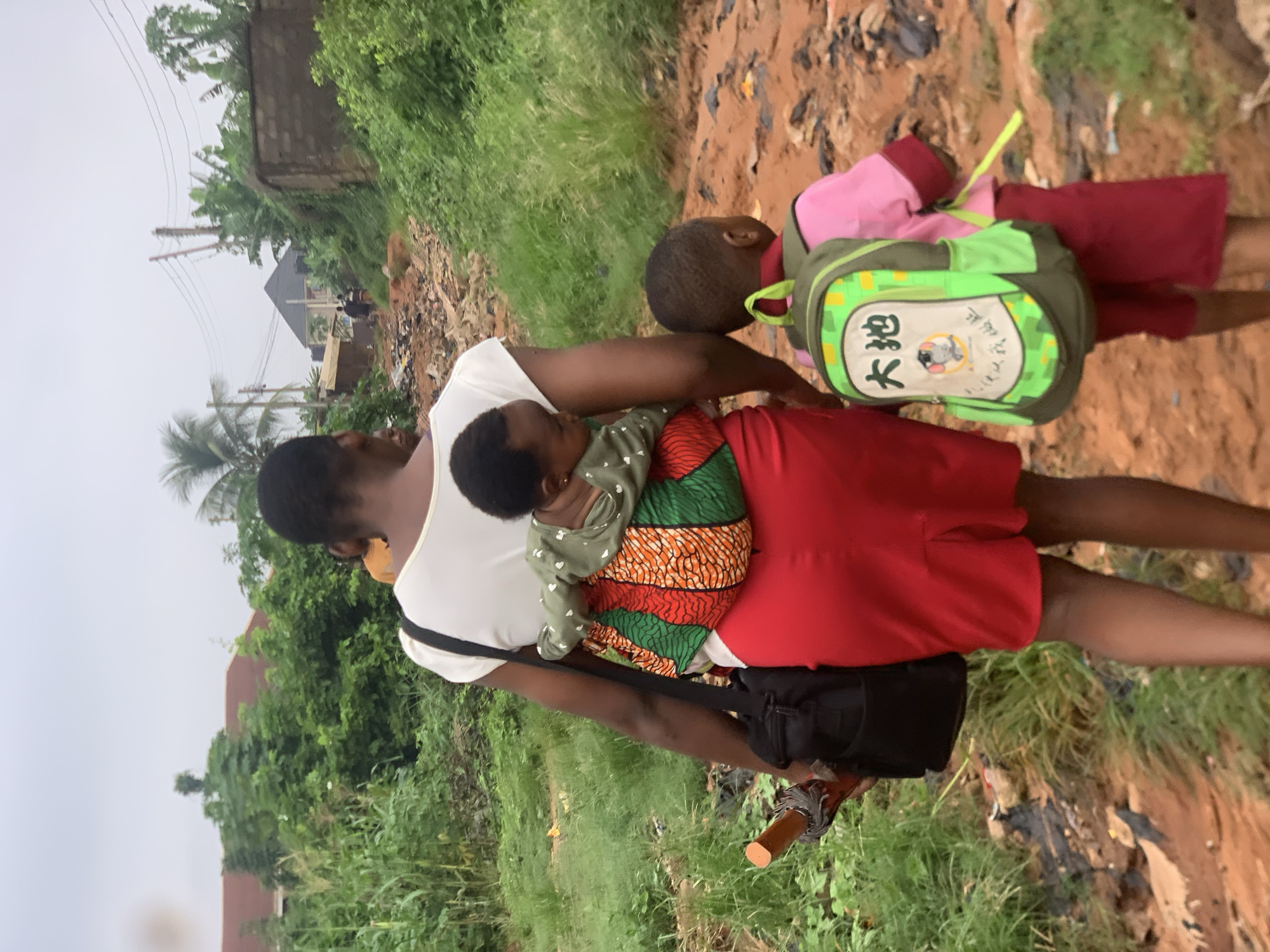 Morning foot traffic along a dirt road in Ukwu-Abwa, Nigeria