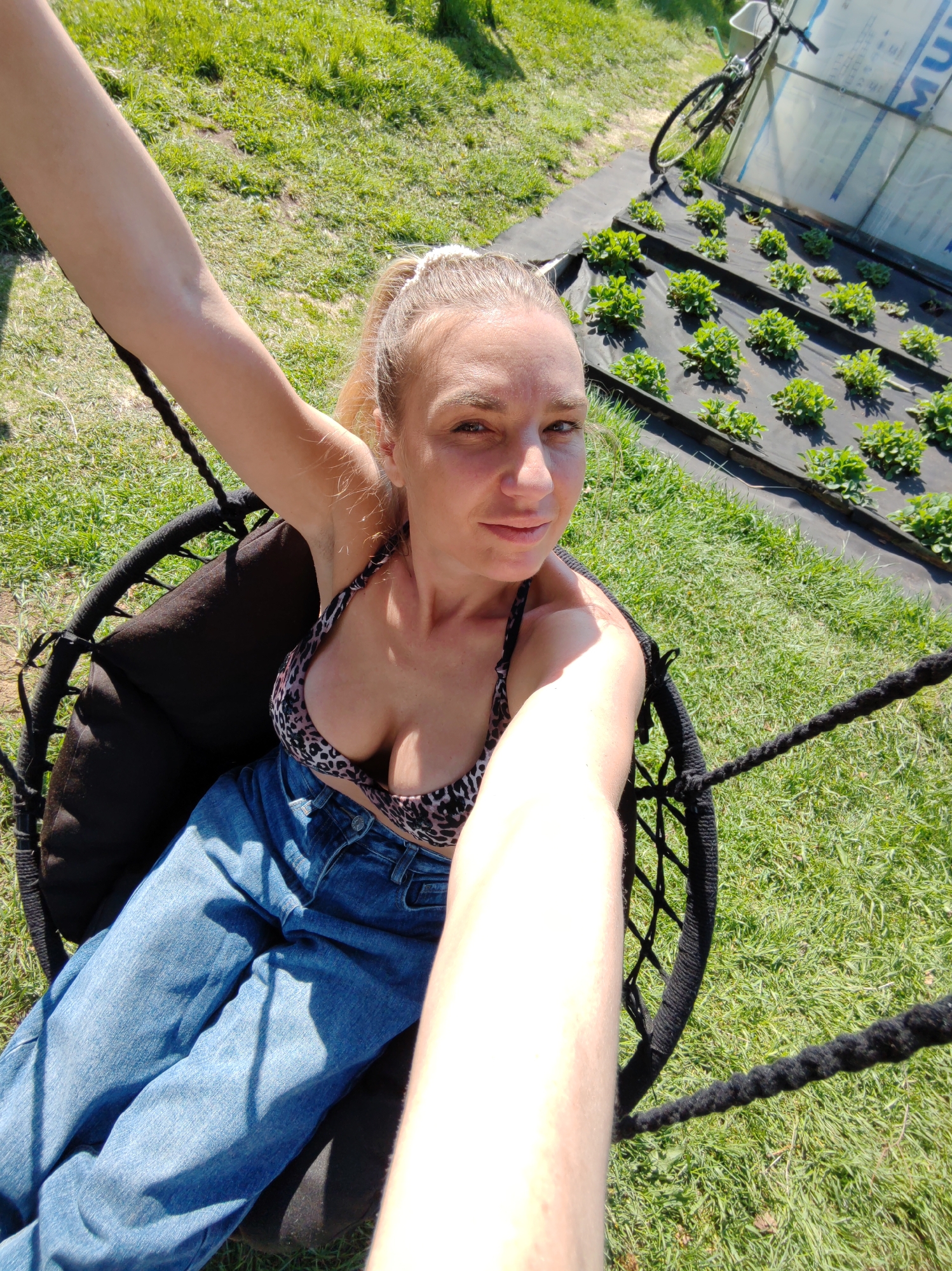 Woman enjoys outdoor swing session with cooking setup nearby