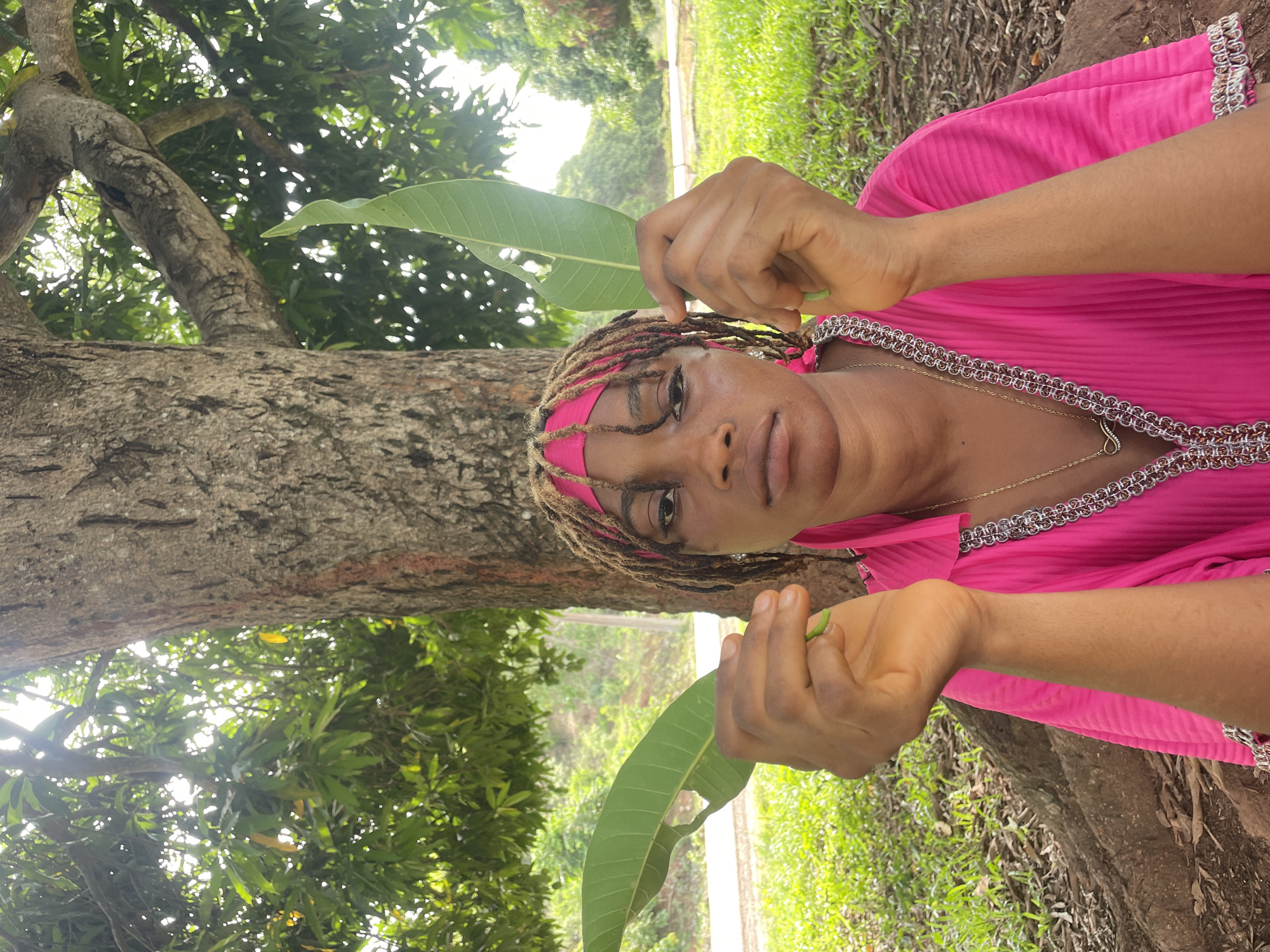 Woman poses with mango leaves in outdoor Nigeria portrait