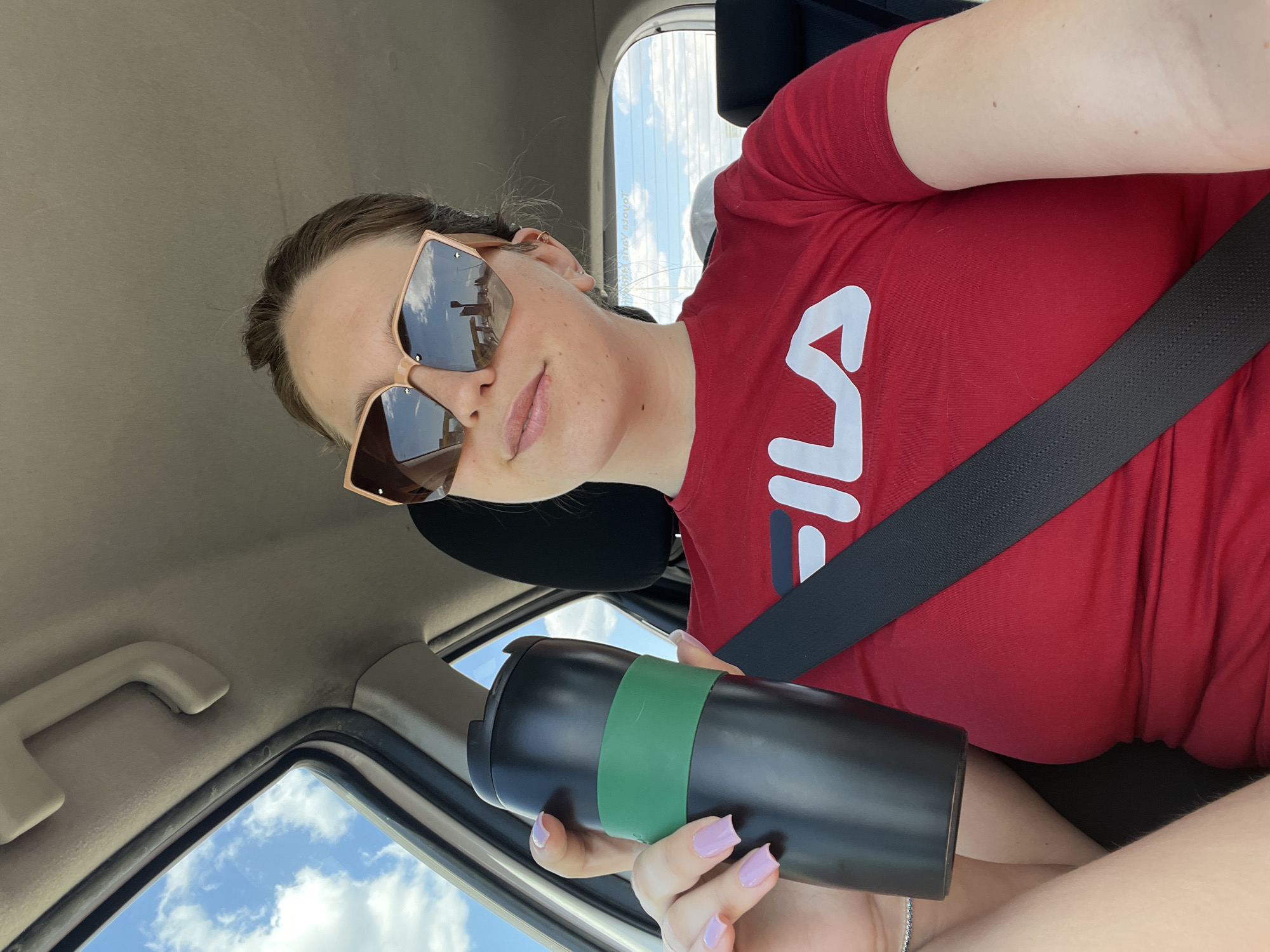 Woman in red Fila shirt observed in car, Montenegro
