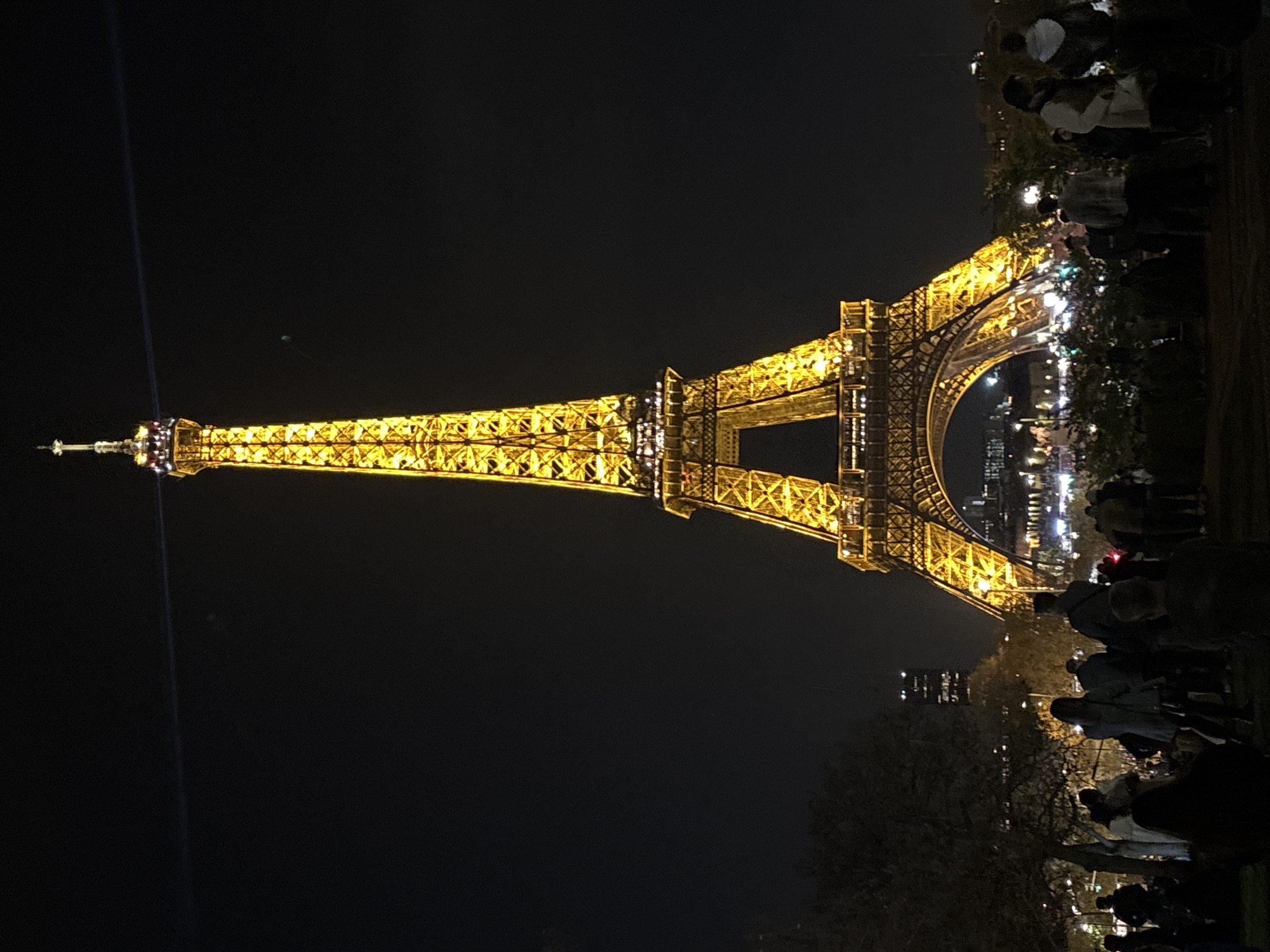 Eiffel Tower draws evening crowds under golden illumination