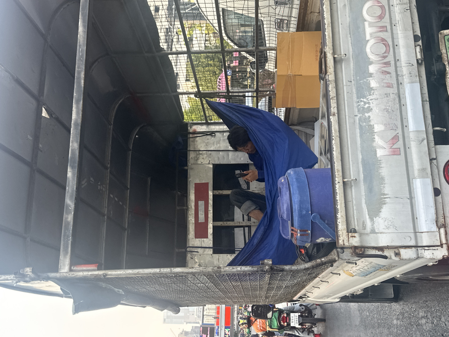 Man rests in utility truck on Bangkok street